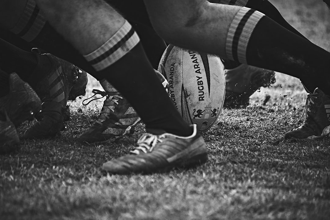 Rugby ball resting on grass, symbolising the sport's connection to charity