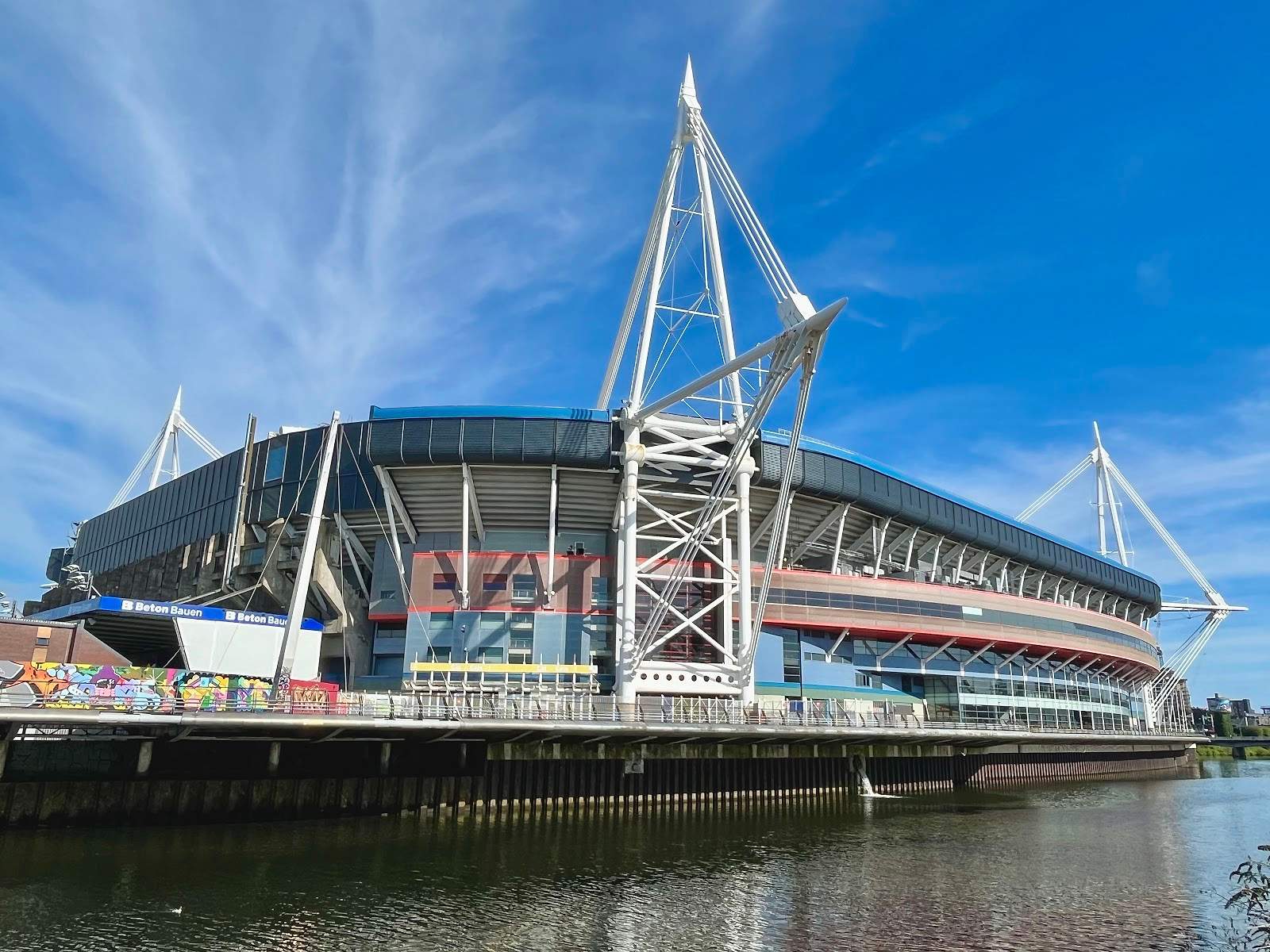 The Principality Stadium seen across the River Taff, its white masts rising against a clear sky
