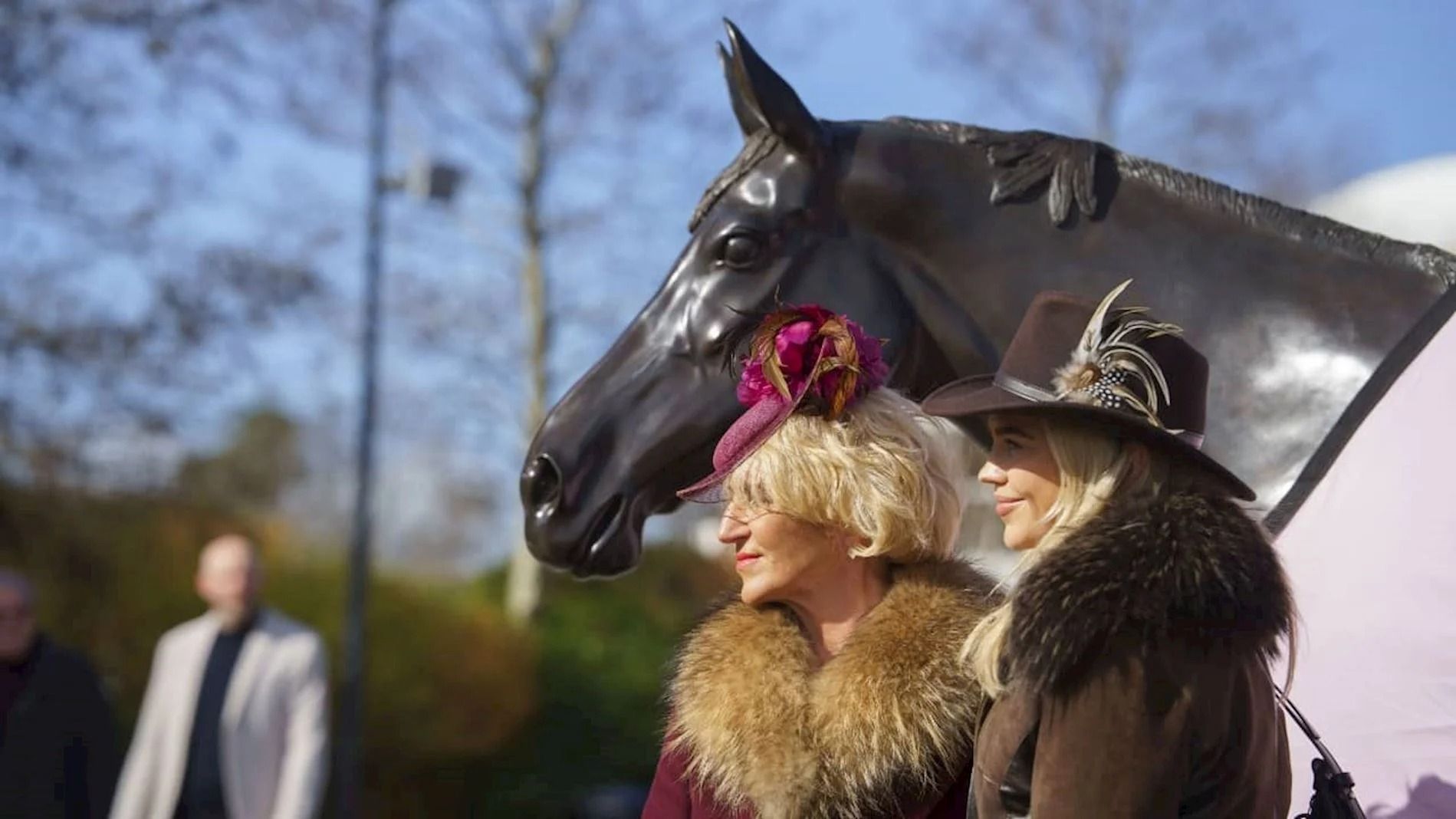 Women standing next to horse statue at Cheltenham Raacecourse