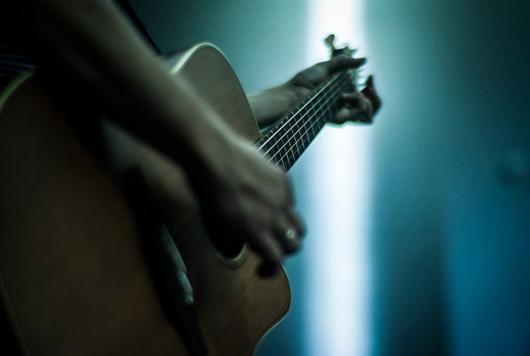 Acoustic guitar performer under spotlight