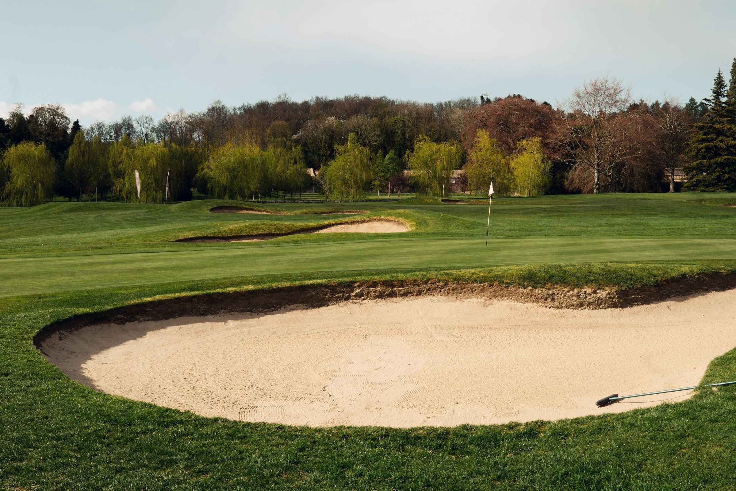 Ryder Cup-style golf scene (A sand trap on a lush green golf course.)