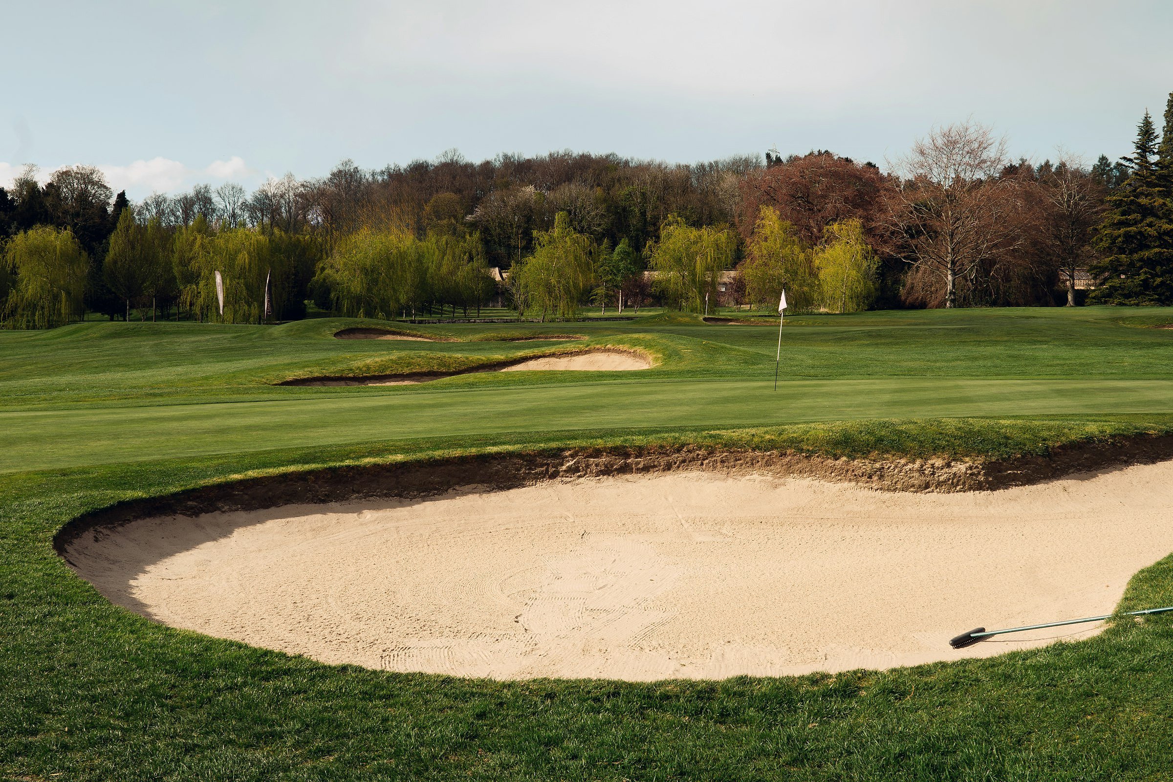 Ryder Cup-style golf scene (A sand trap on a lush green golf course.)