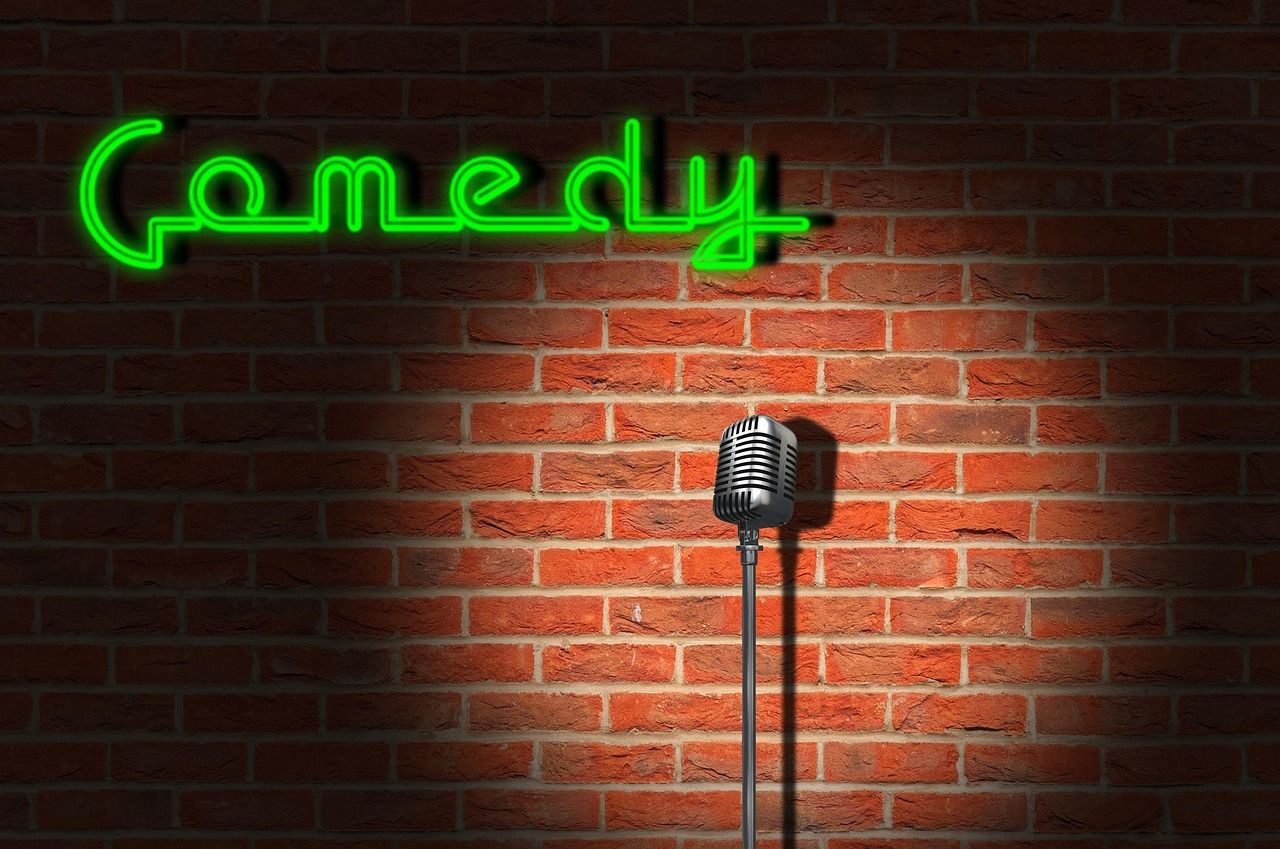 A neon-lit comedy club stage, the kind of intimate venue where Jack Whitehall started out