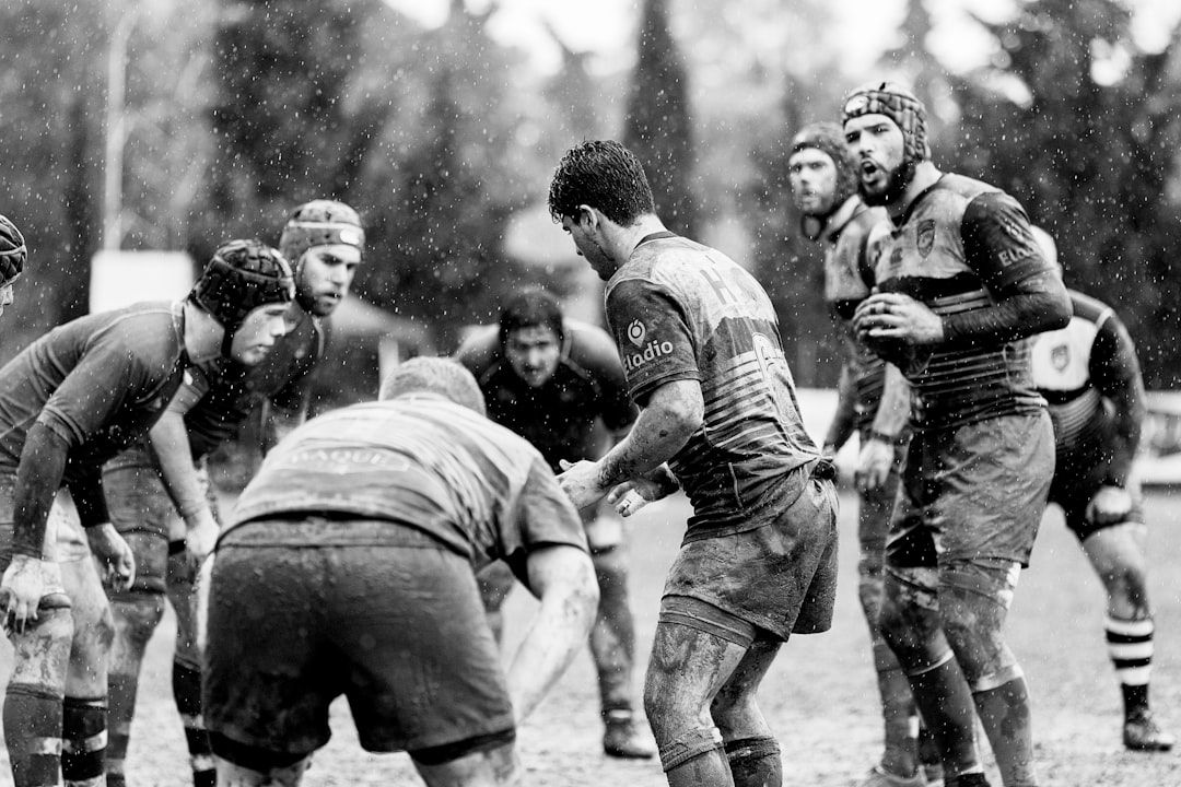 Rugby players competing in muddy conditions, evoking the rugged early days of international rugby