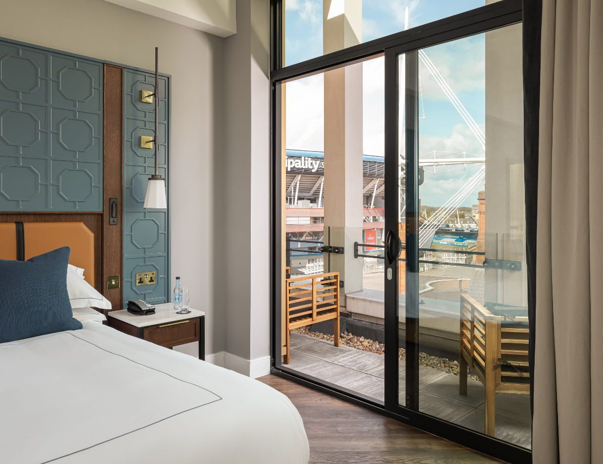 A bedroom at The Parkgate with sliding doors onto a balcony, the Principality Stadium directly opposite