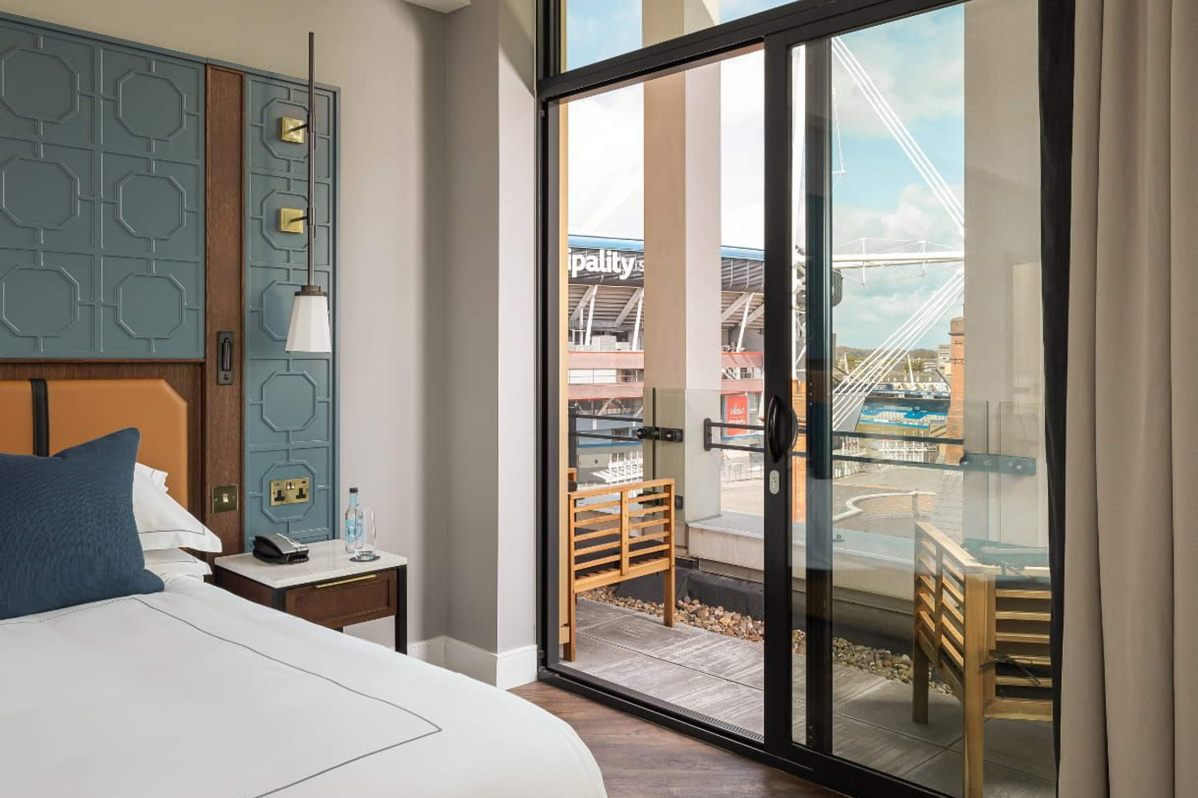 A bedroom at The Parkgate with sliding doors onto a balcony, the Principality Stadium directly opposite