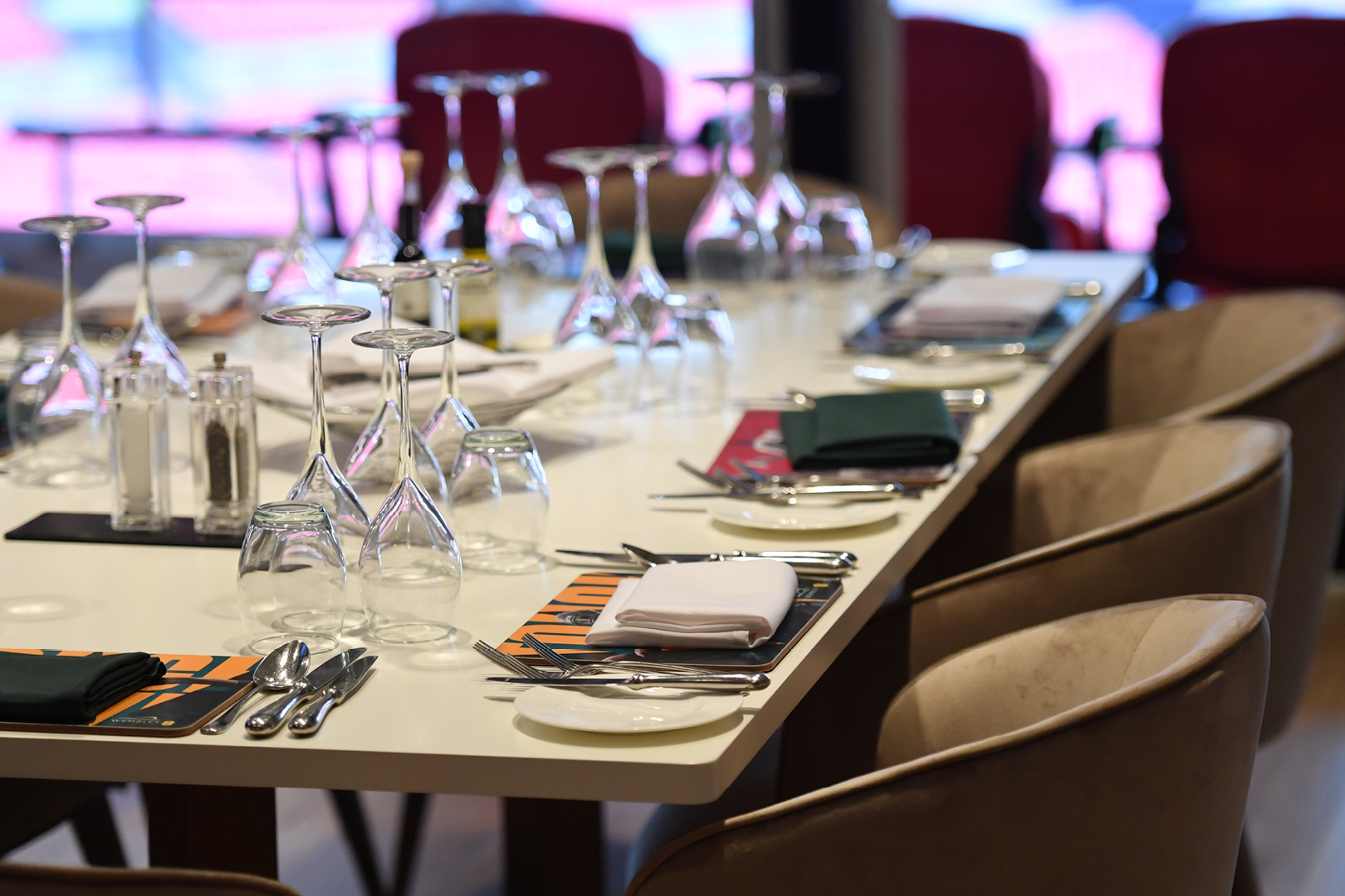 A table laid with glasses and place settings inside a private box at Wembley