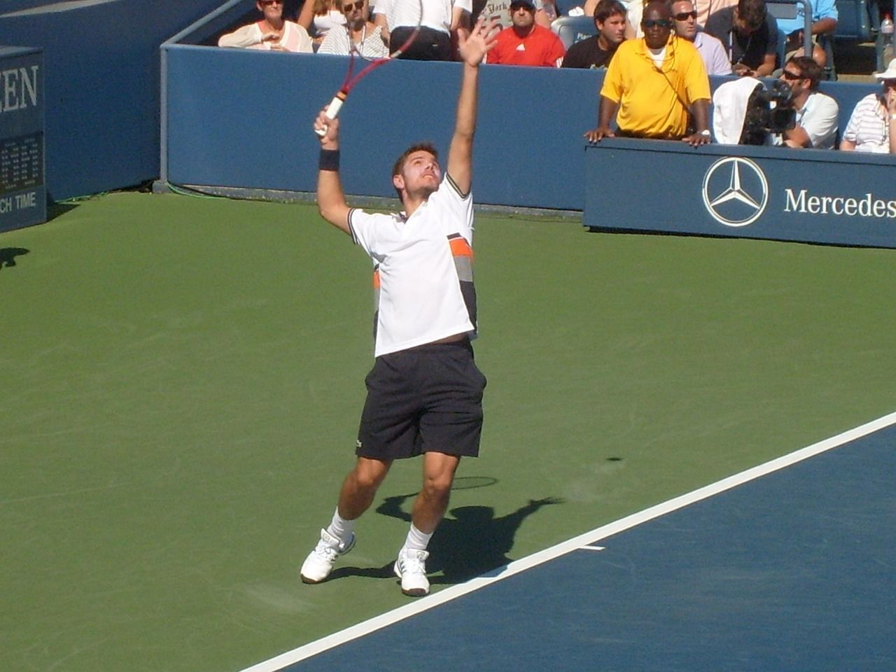 Professional tennis player serving during a competitive match