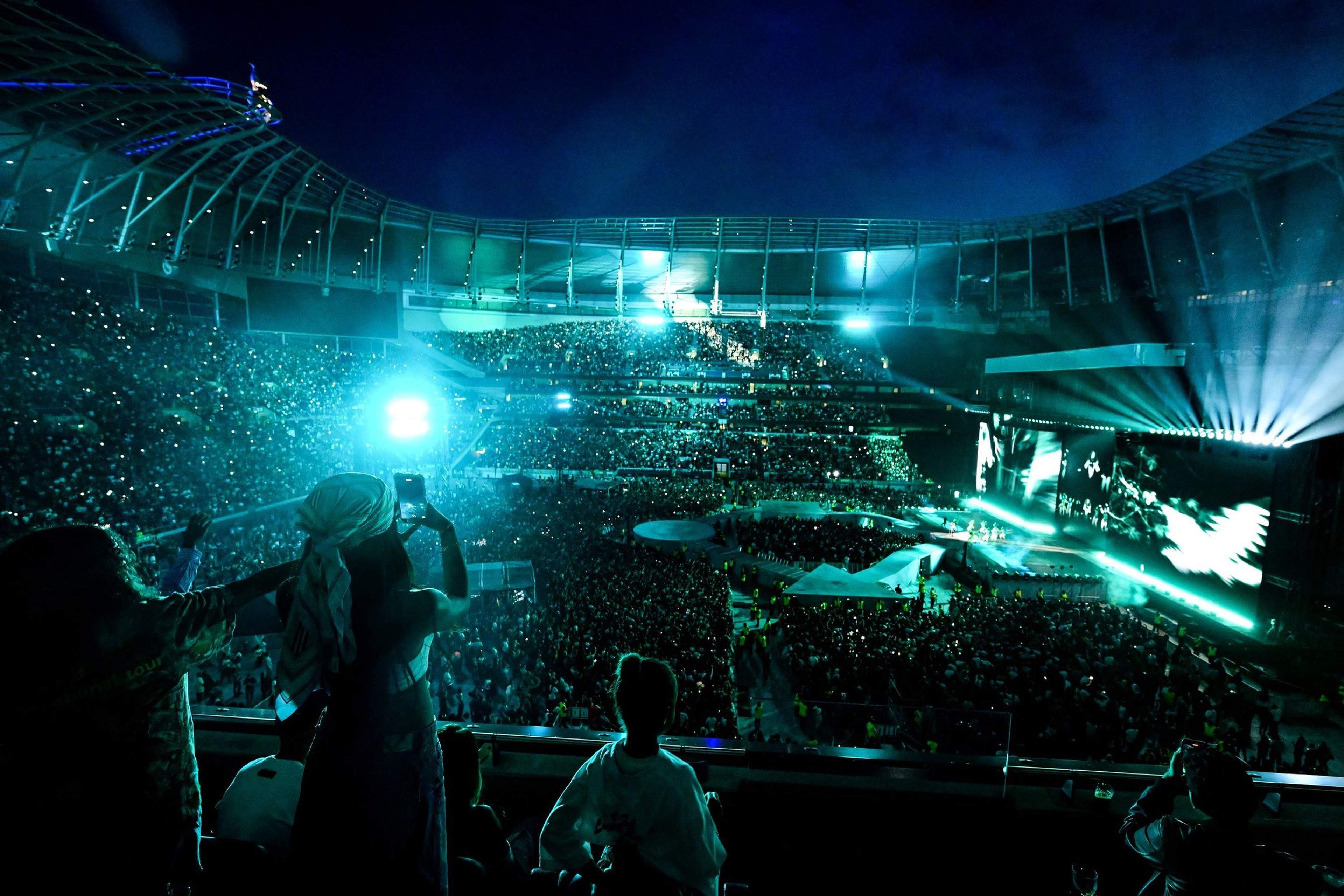 Photo for illustration: a concert at Tottenham Hotspur Stadium lit in teal, seen from the stands