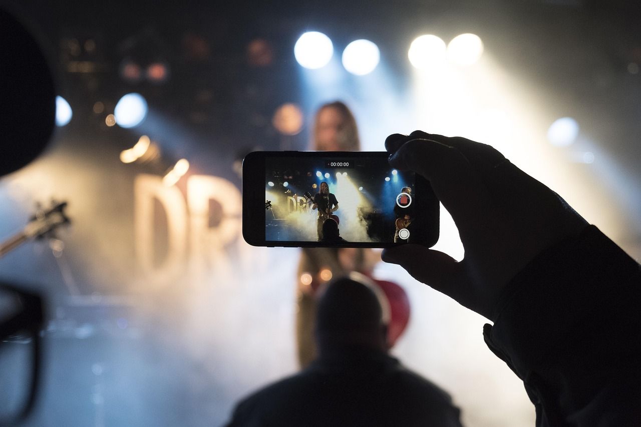 Concert crowd holding up smartphones during a live performance
