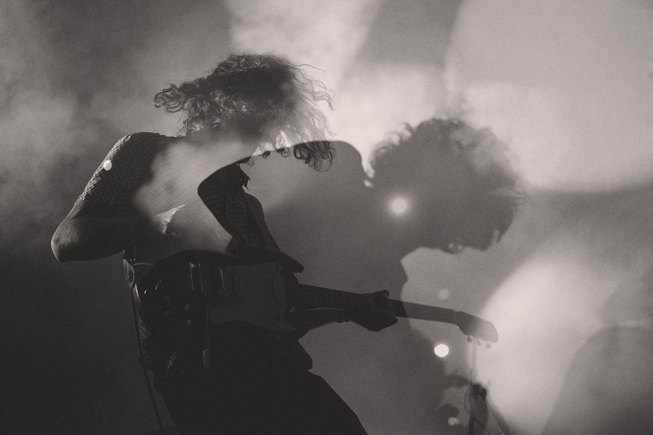 Electric guitarist performing on stage in black and white with smoke effects