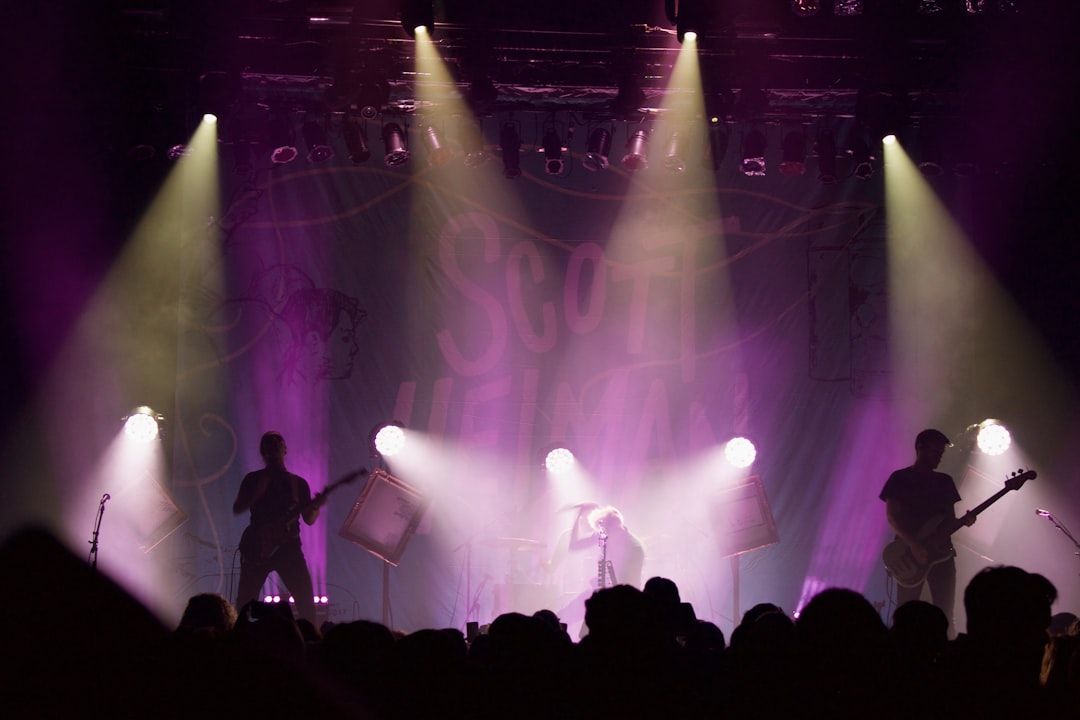 A large pop concert stage in a packed arena with dramatic lighting
