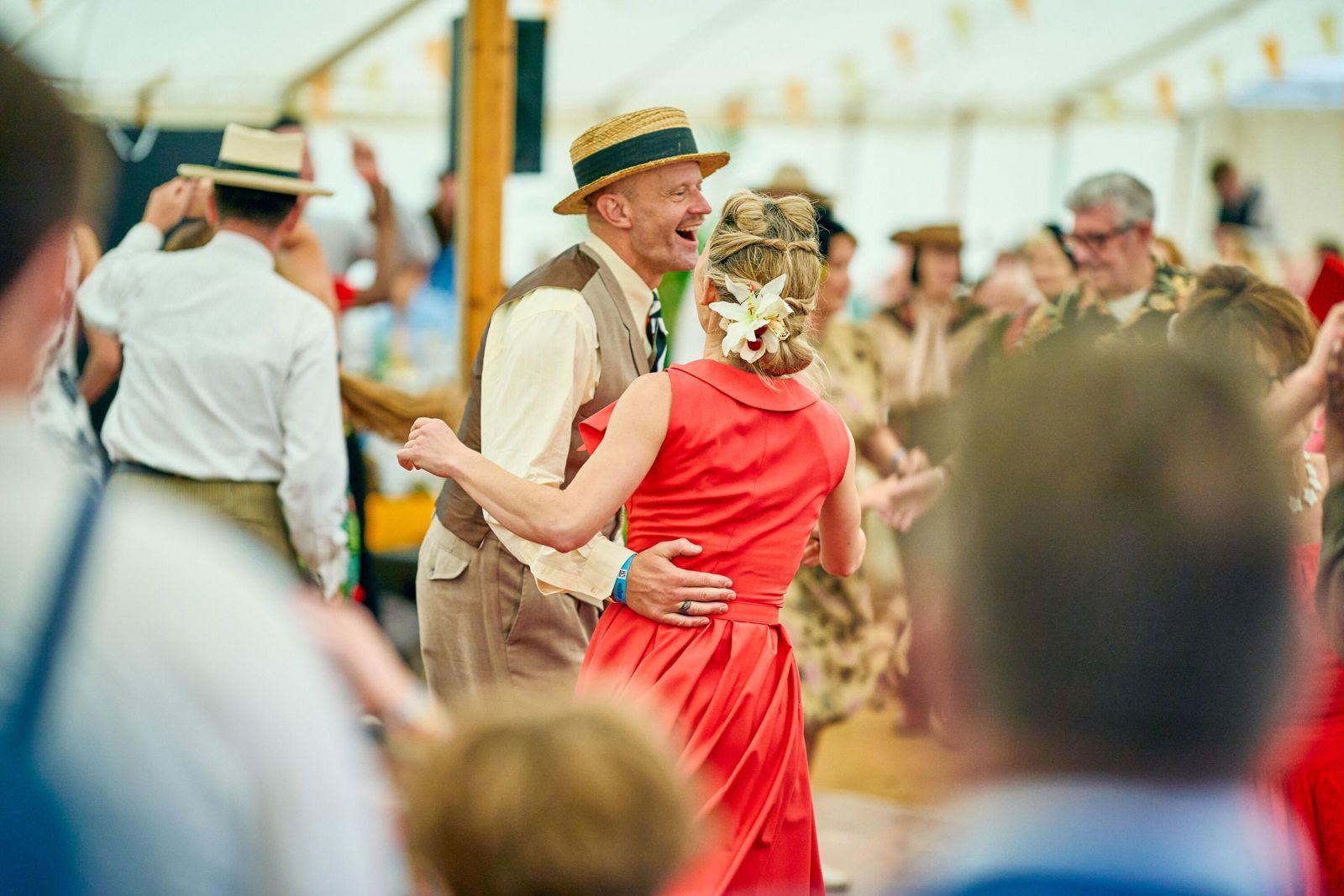 Spectators in period costume dancing at the Goodwood Revival