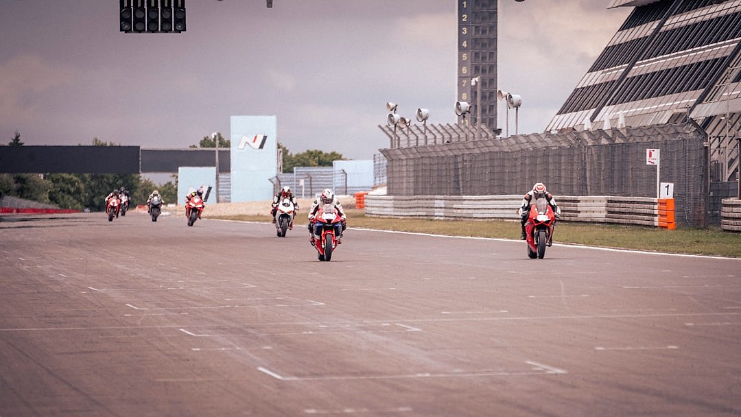 MotoGP riders racing closely on a circuit