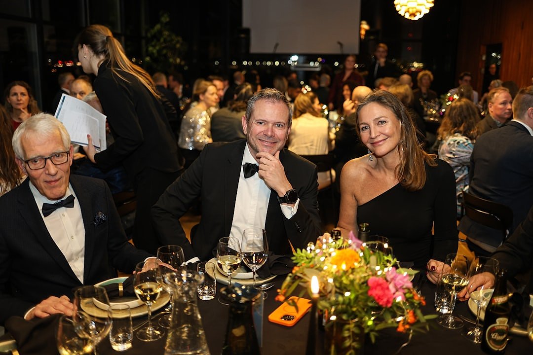 Formal charity dinner setting with guests at elegantly dressed tables