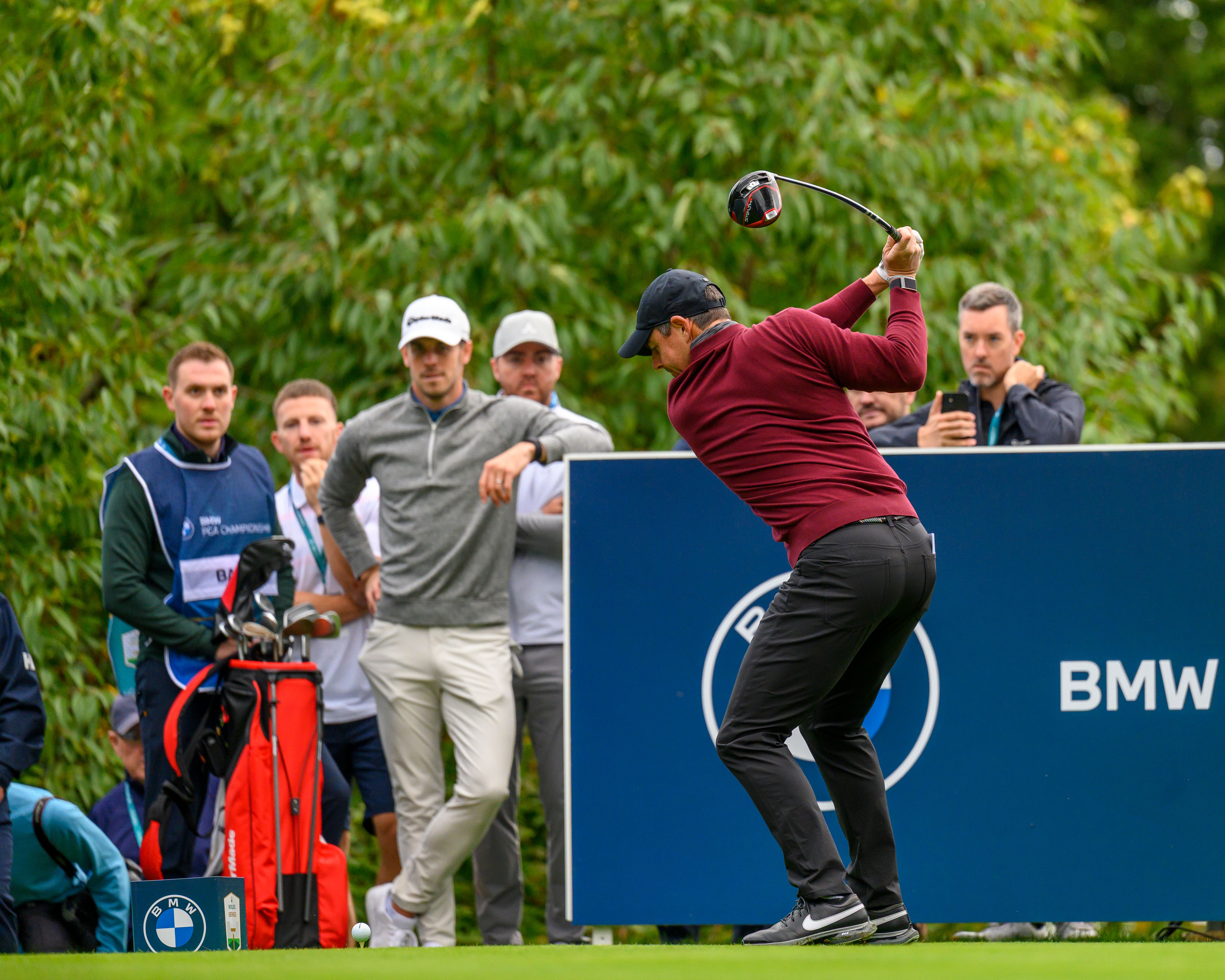 Rory McIlroy drives during the Wentworth Pro-Am as Gareth Bale and spectators watch