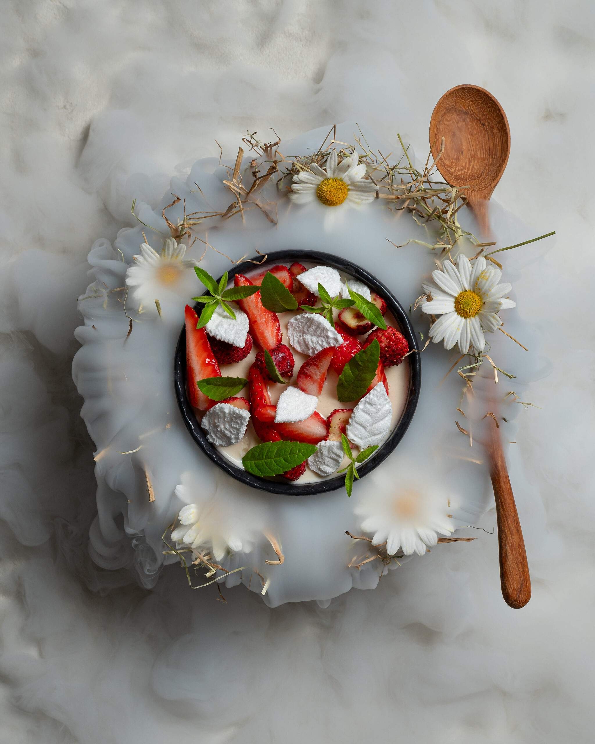 Strawberries and meringue in a bowl ringed with daisies at HIDE