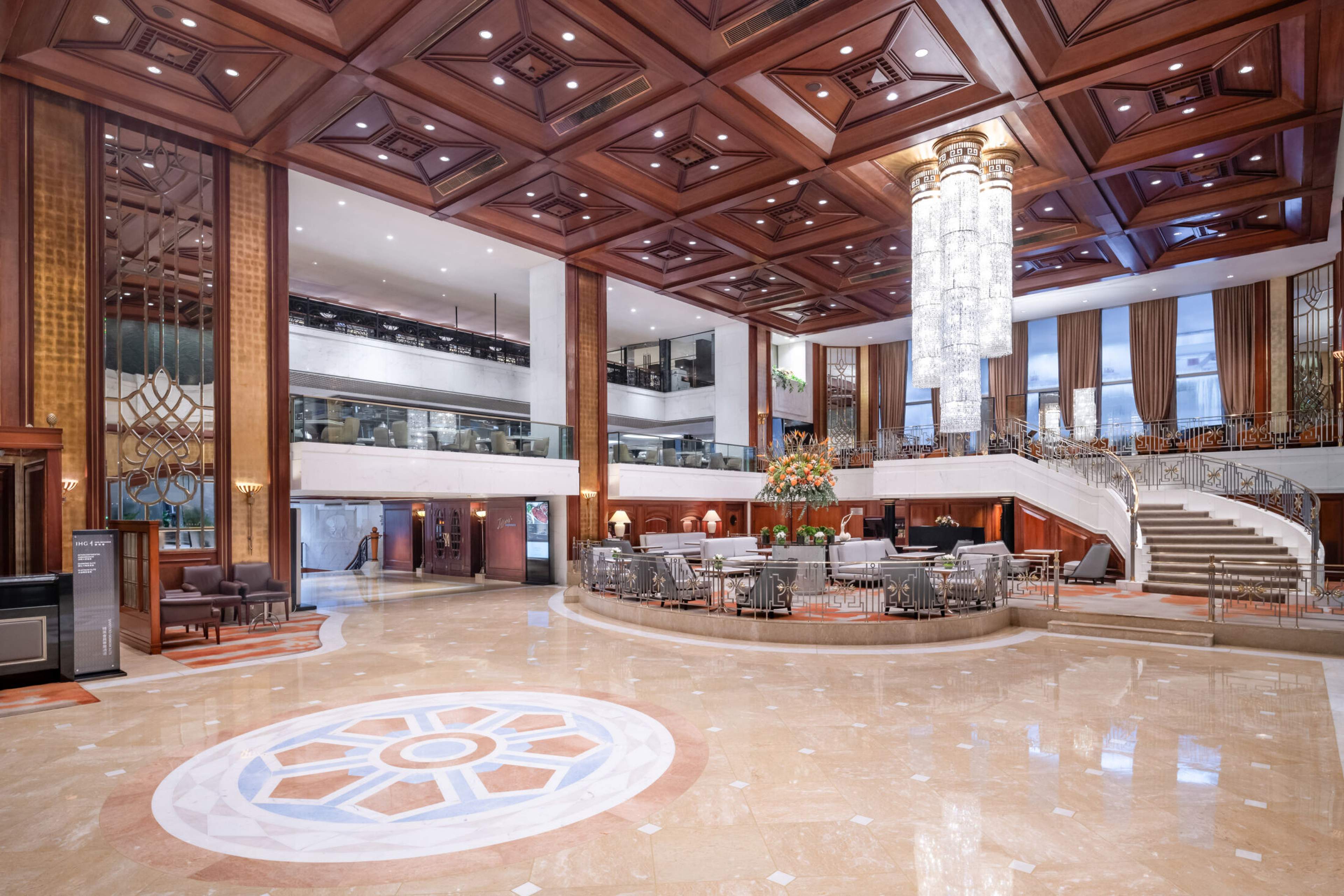 The lobby of the InterContinental Grand Stanford Hong Kong, coffered wood ceiling and a chandelier above the marble floor