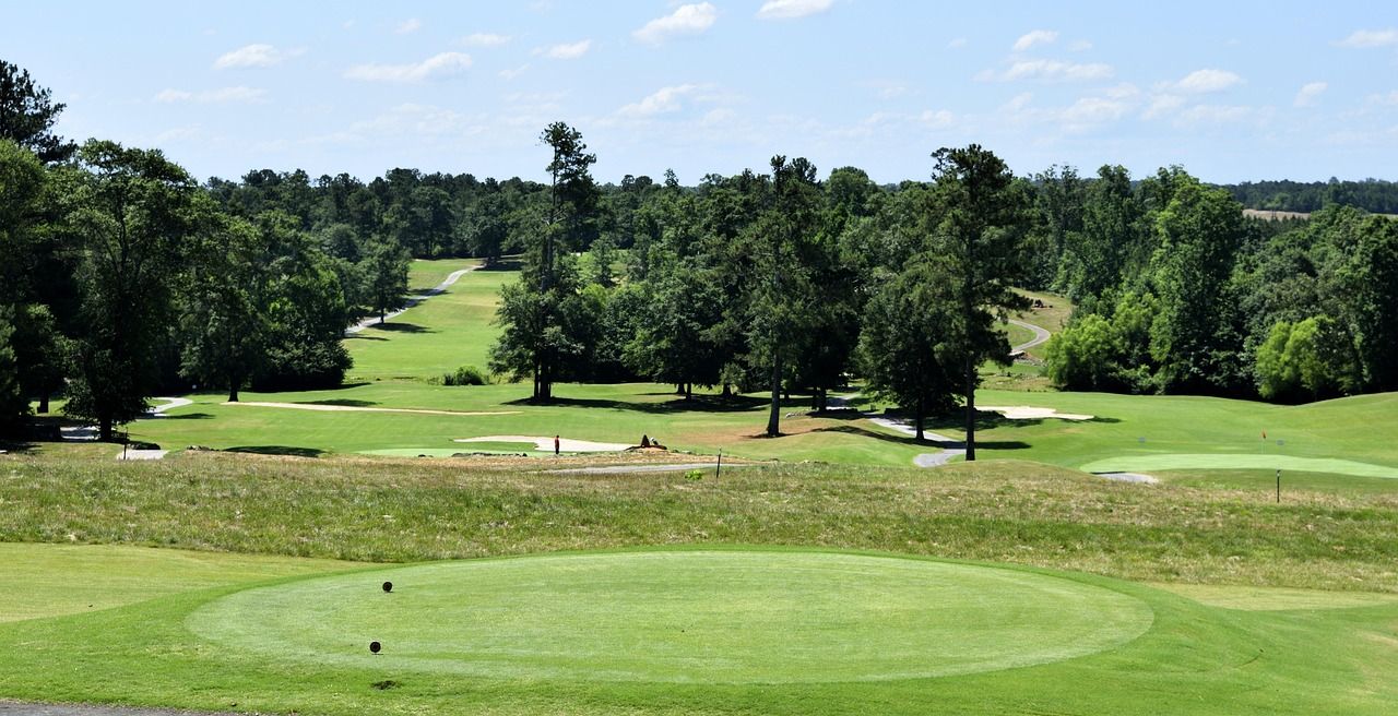 Championship golf course fairway with bunkers and tree-lined landscape