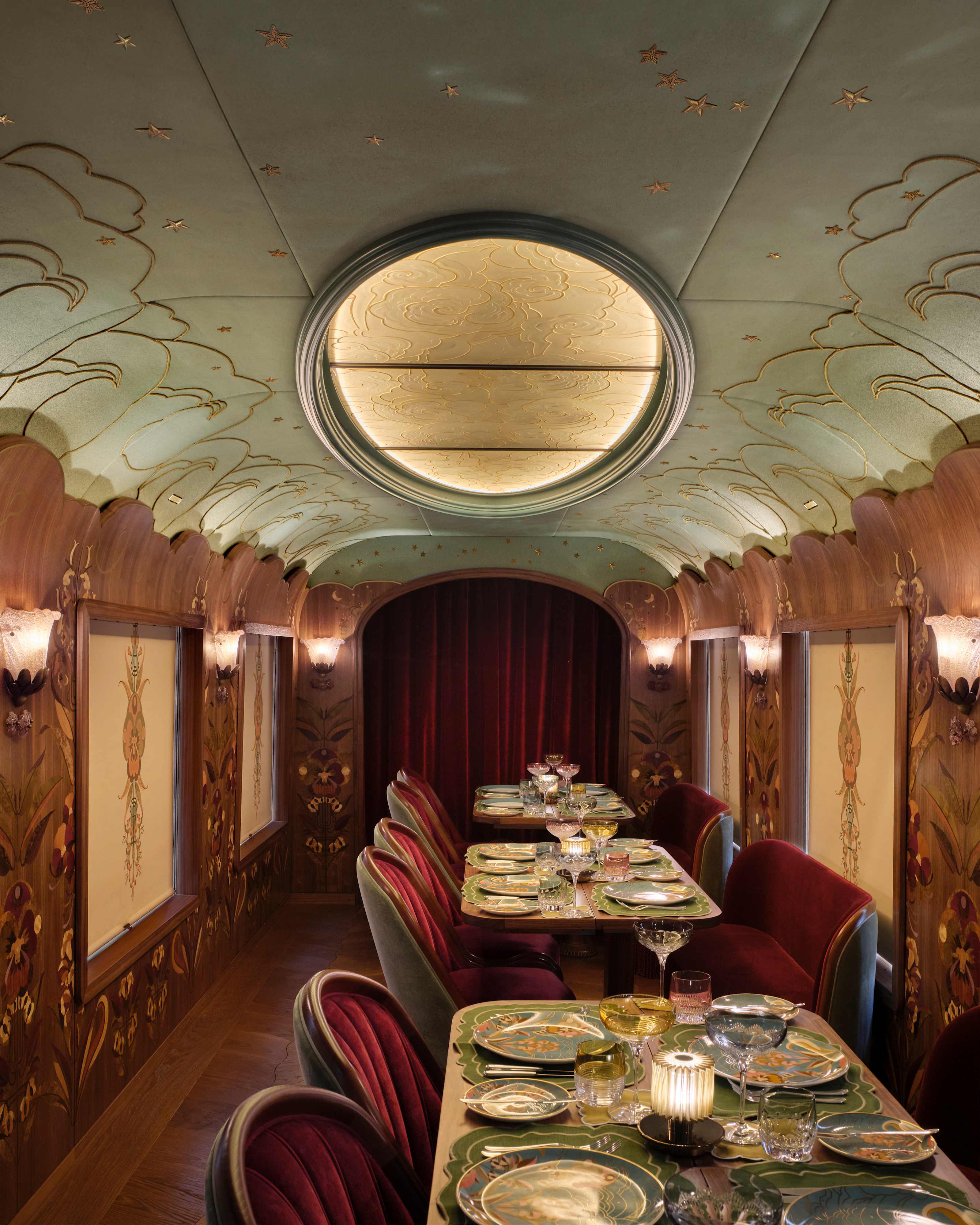 Dining tables in the Celia carriage beneath a domed ceiling light