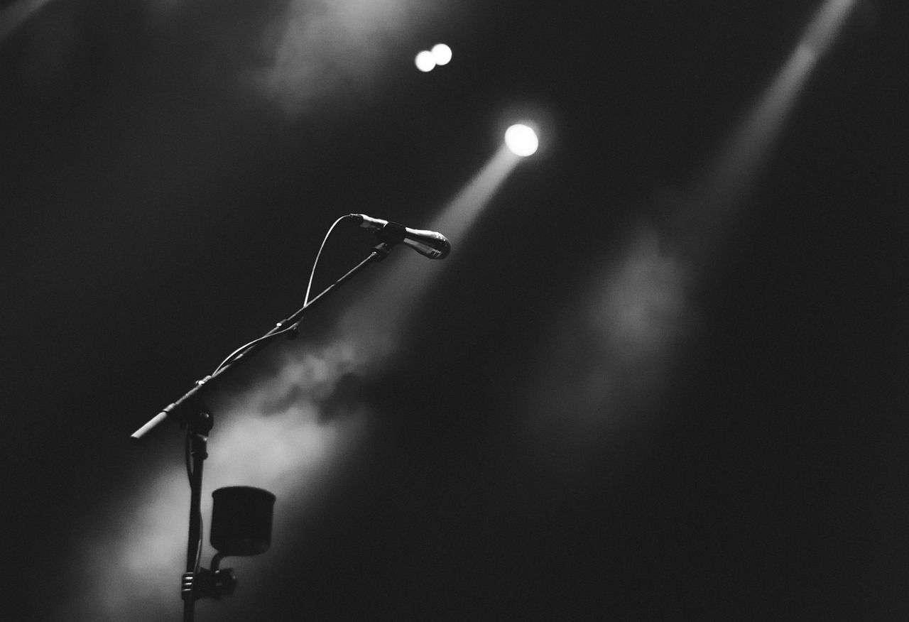 Microphone on a smoky stage under dramatic spotlight