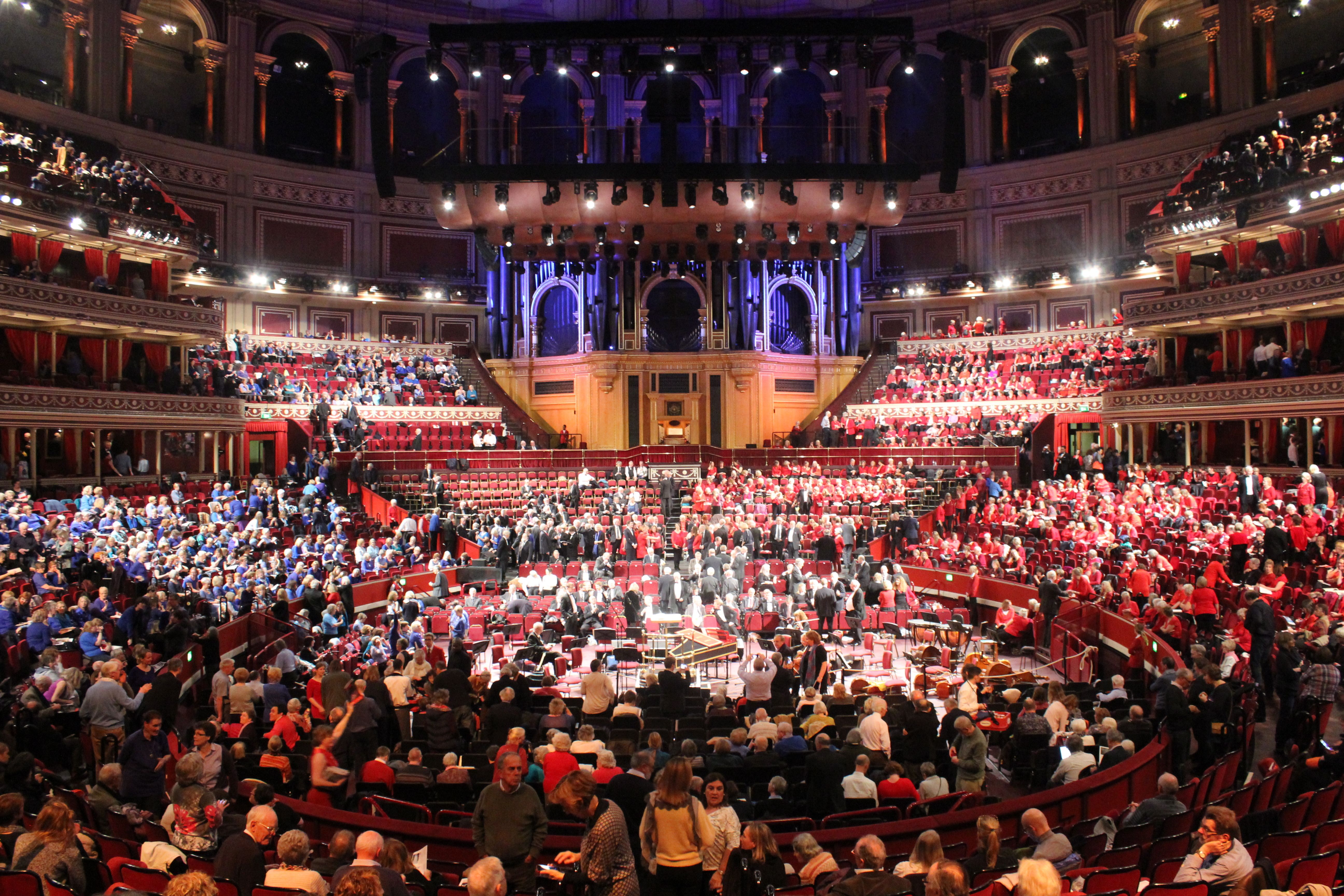 A full Royal Albert Hall during a choral concert, with the audience in boxes beside the Stalls