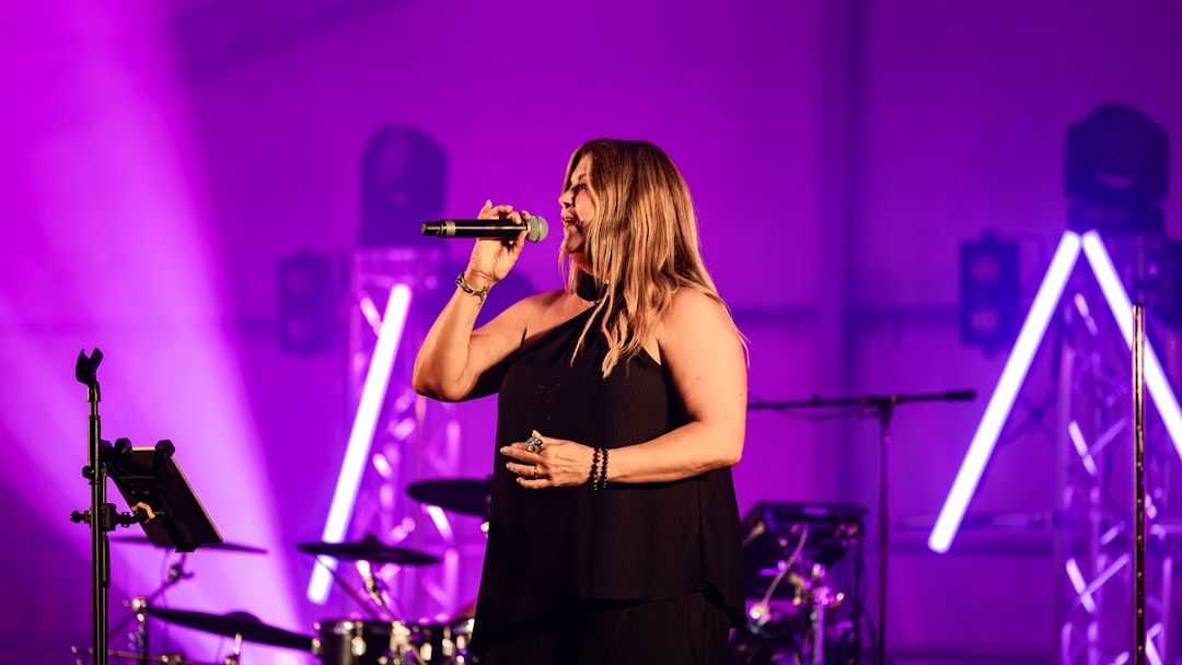 A singer performing on stage under a spotlight