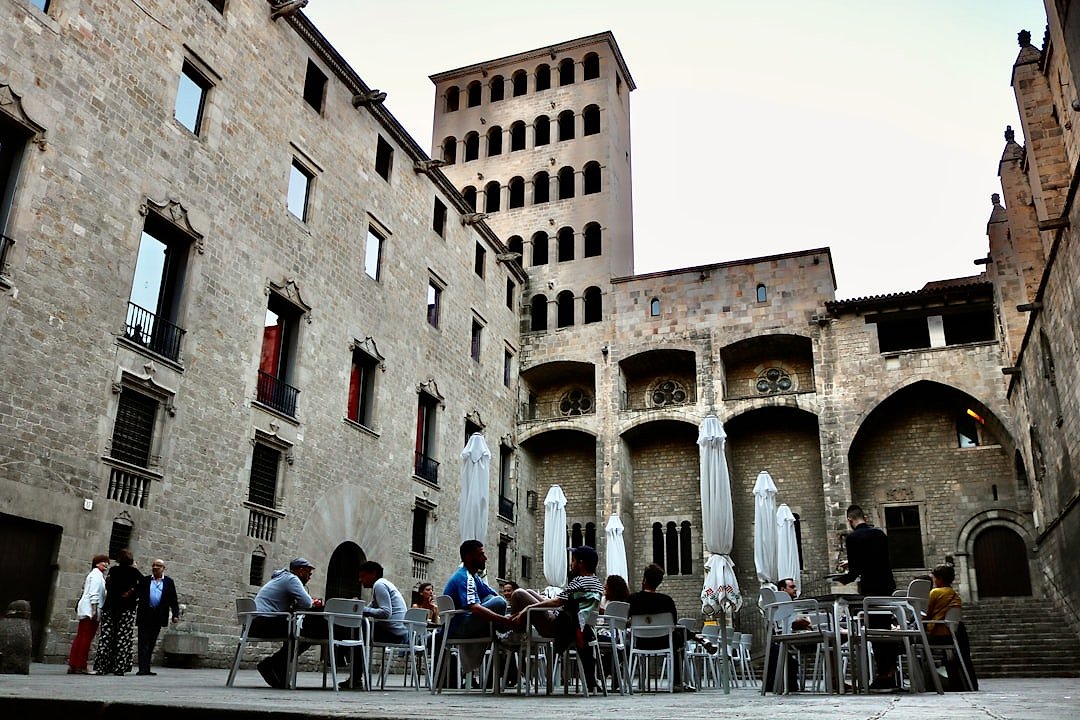 Outdoor dining in Barcelona's Gothic Quarter with historic architecture