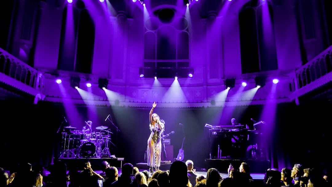 Concert singer performing on stage under dramatic lighting