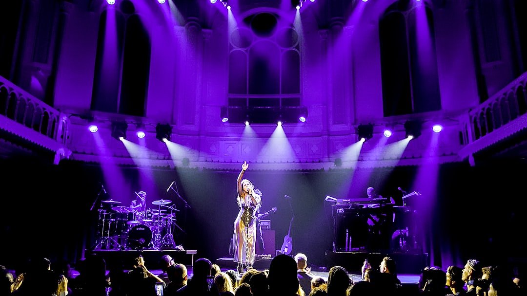 Concert singer performing on stage under dramatic lighting