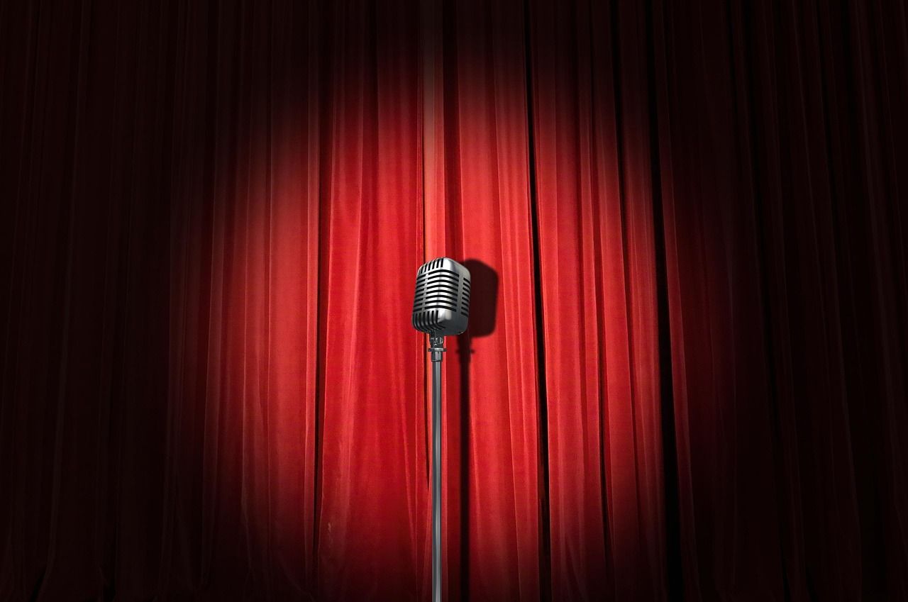 A comedy stage with curtains and warm lighting