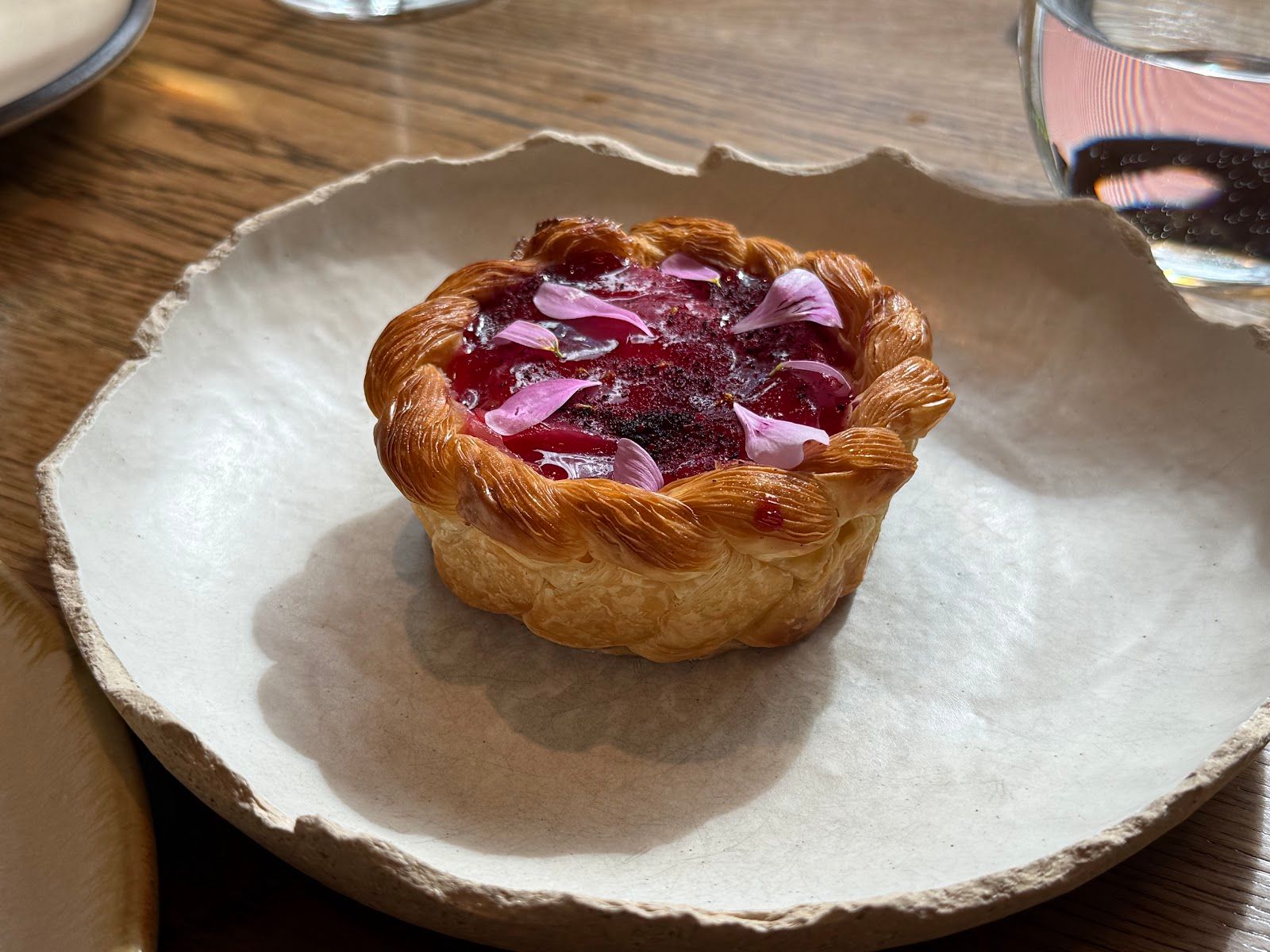 A tart with a fluted pastry case and a glazed red fruit filling at HIDE