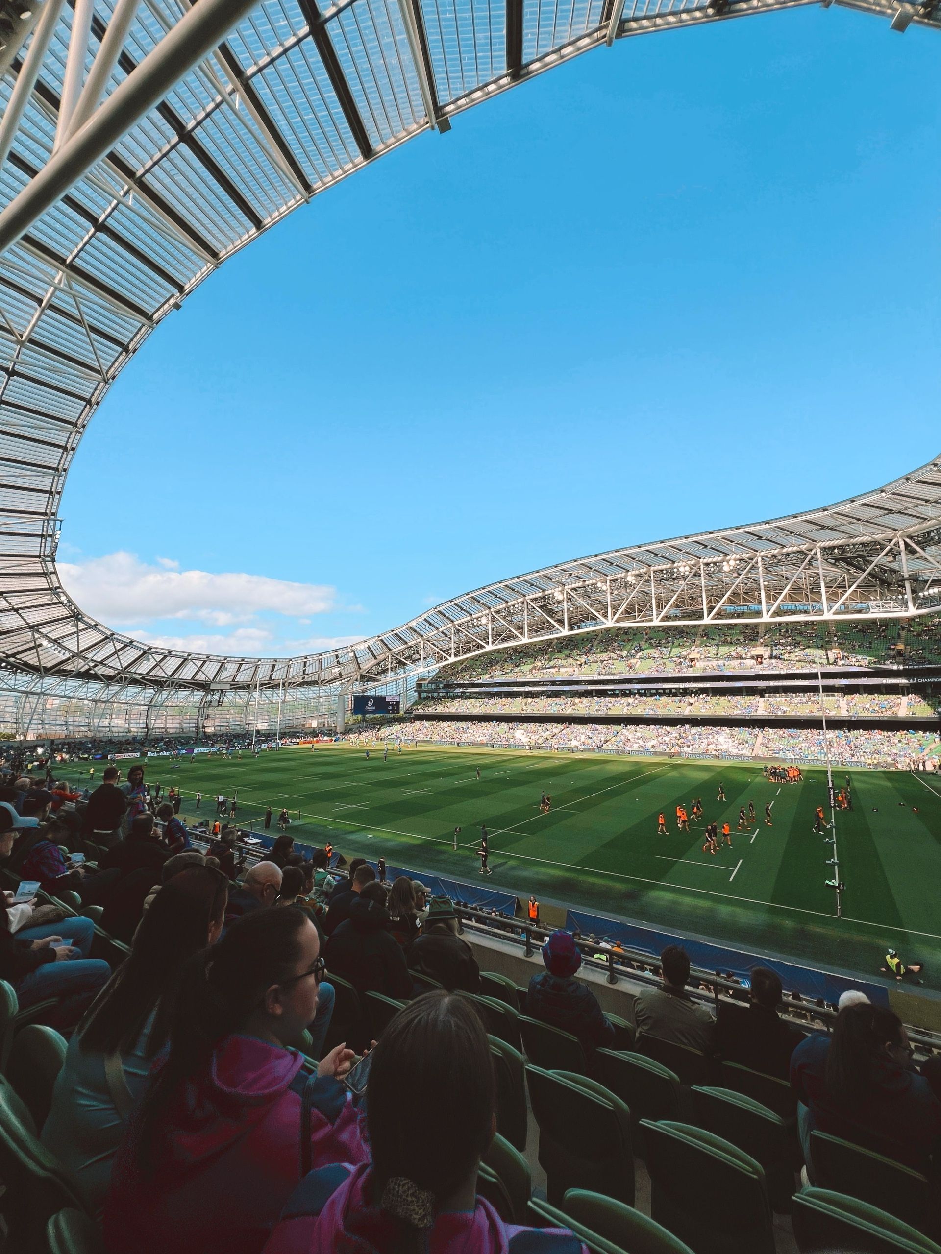 Aviva Stadium seen from the stands on a match day, looking across the pitch to the far stand under the curved roof