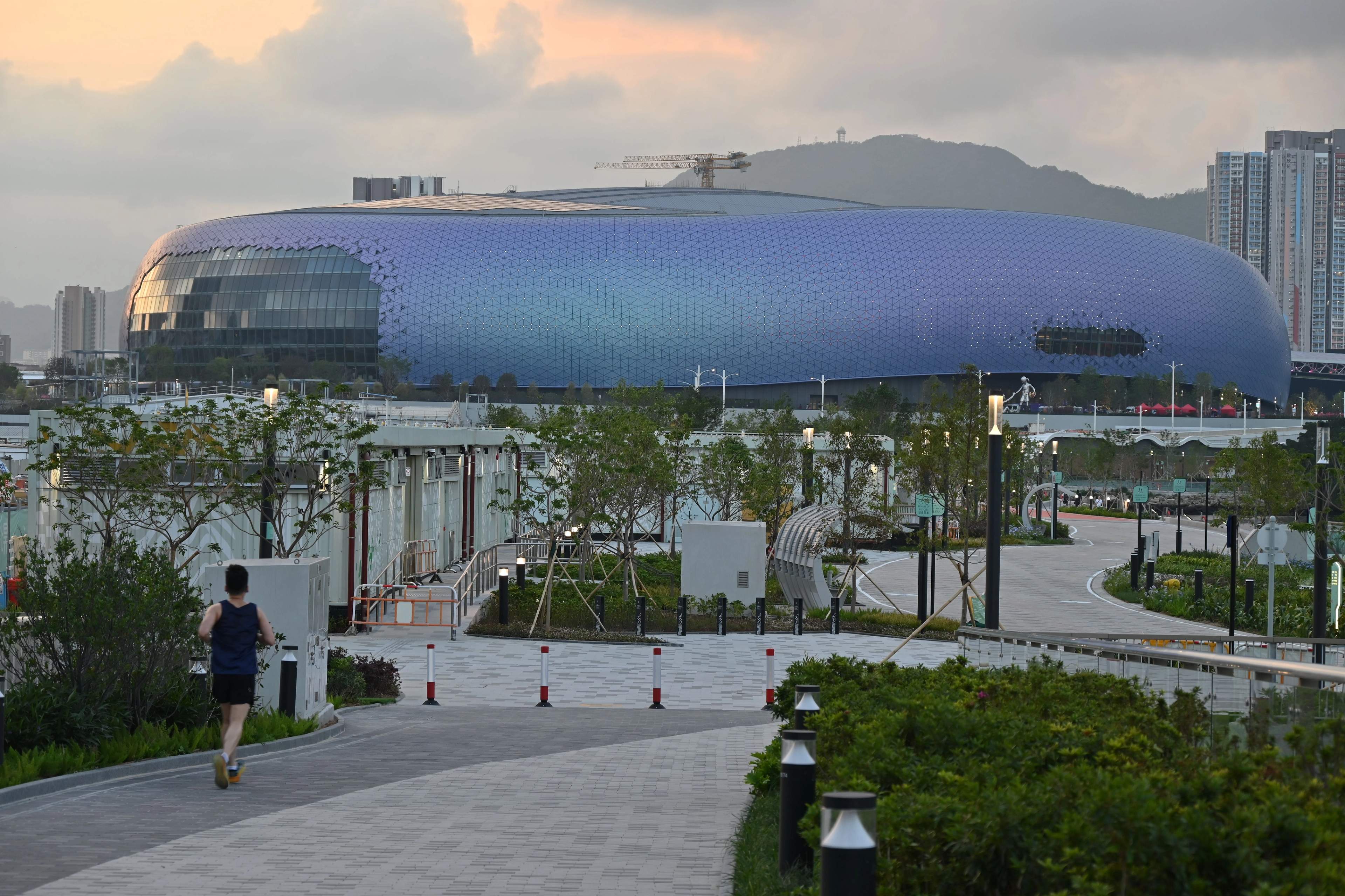 Kai Tak Stadium’s purple exterior at dusk, viewed from the park approach