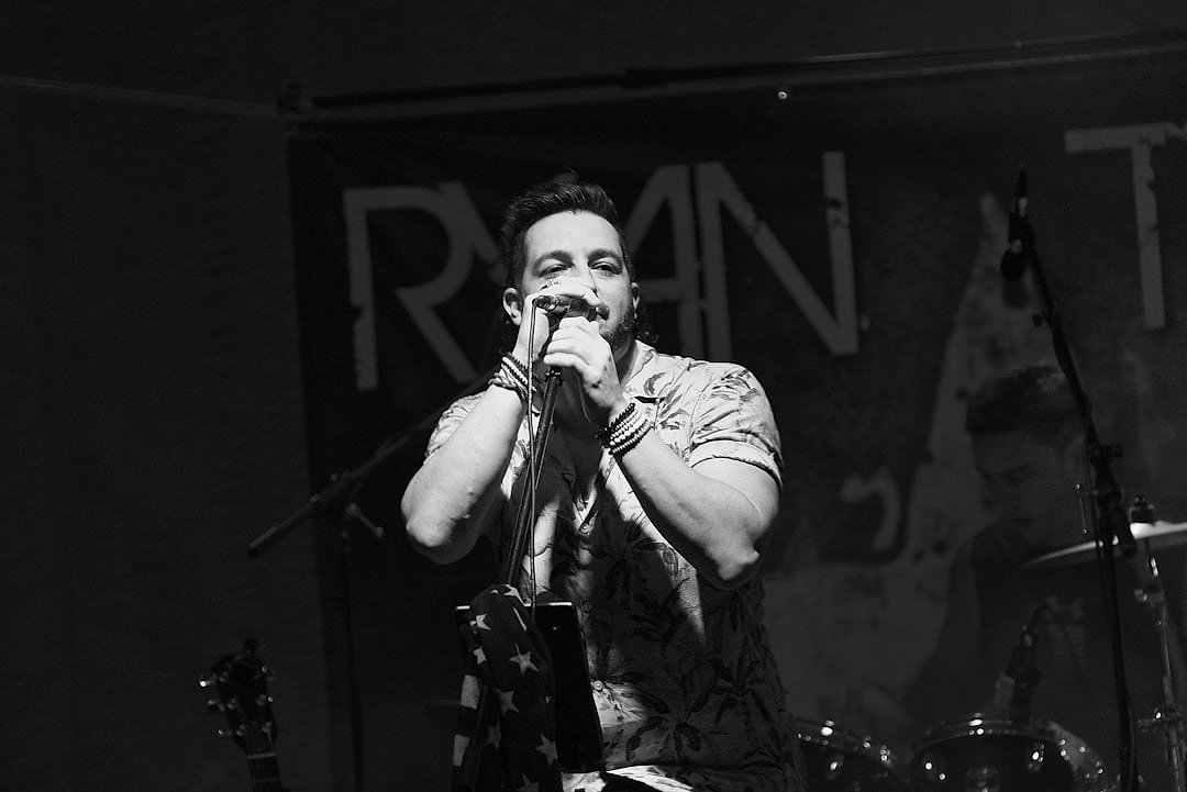 Singer performing on stage under dramatic spotlight