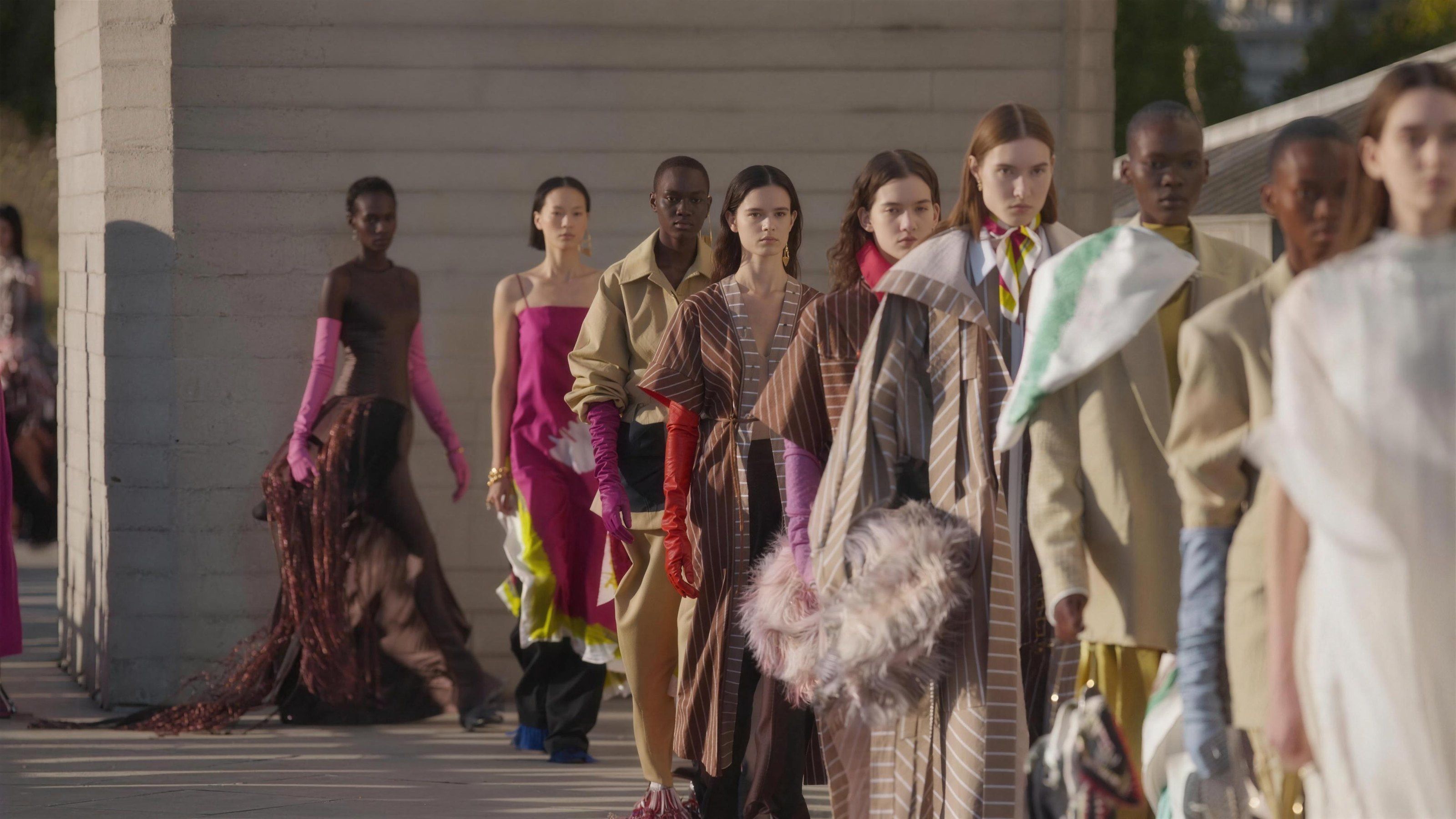Models walk out together in the finale line-up at Roksanda's September 2026 show, against a board-marked concrete wall