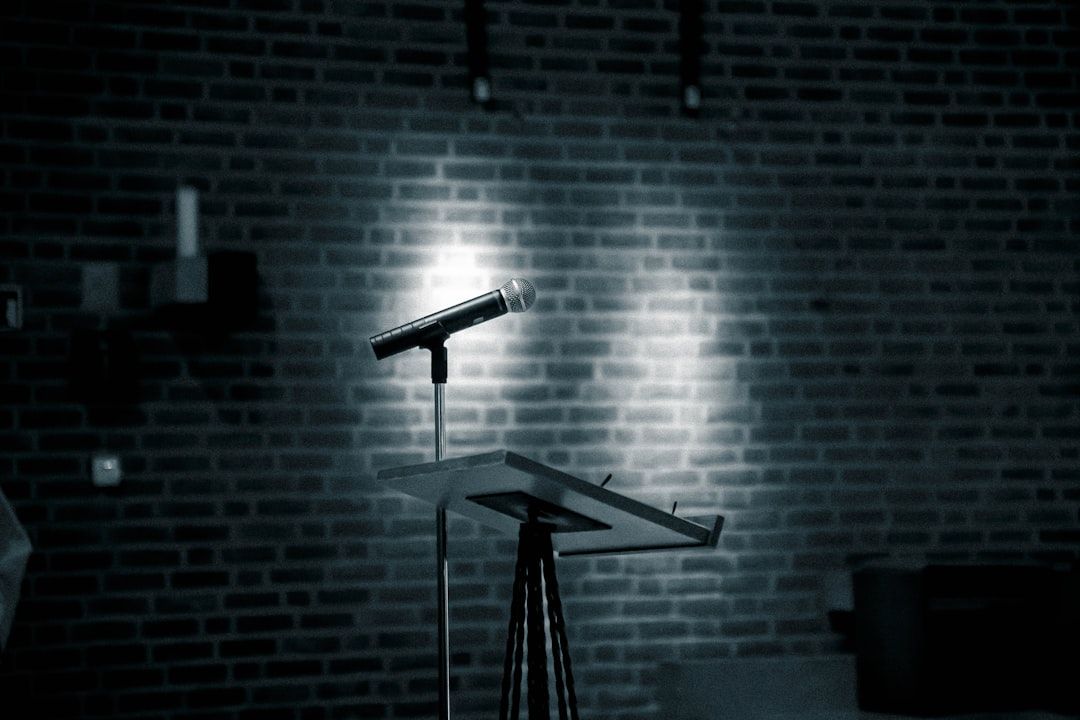 A microphone on a stand in front of a brick wall at a comedy club