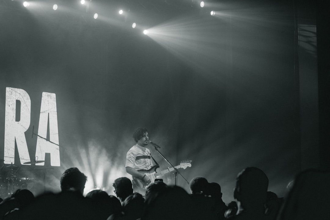 Guitarist performing live on stage in black and white