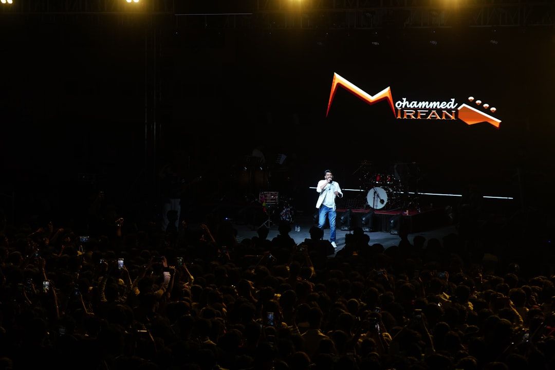 Singer performing live on stage for an excited crowd