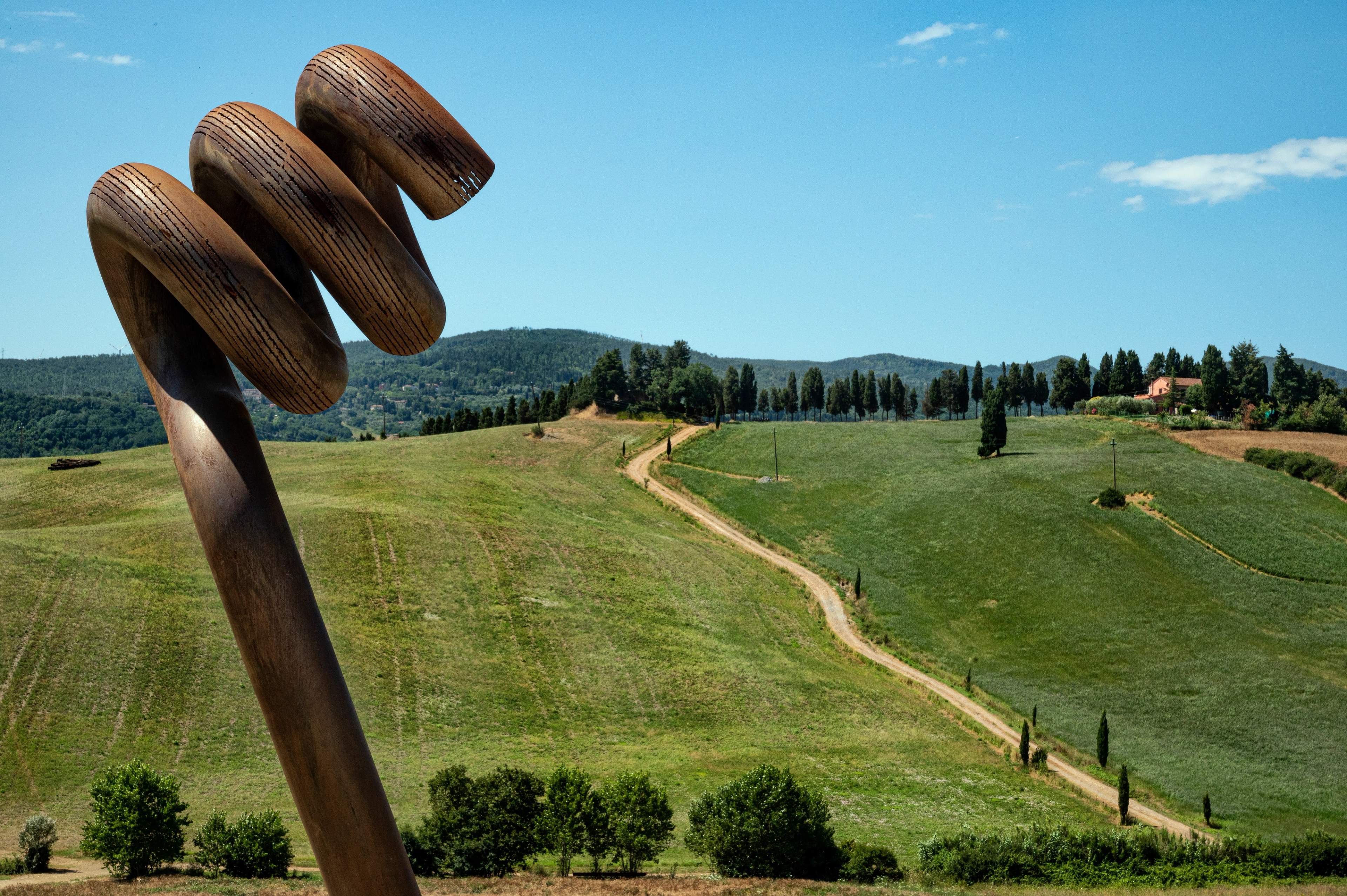 A wooden spiral sculpture above the hills at the Teatro del Silenzio