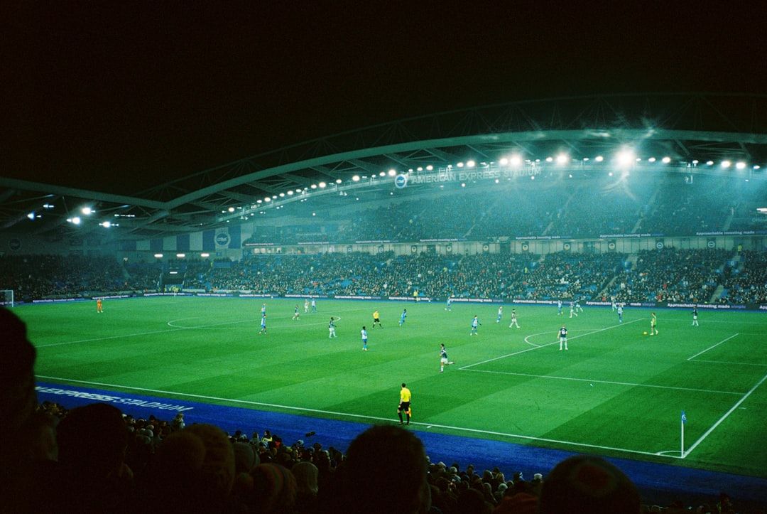 Football stadium under floodlights during a night match