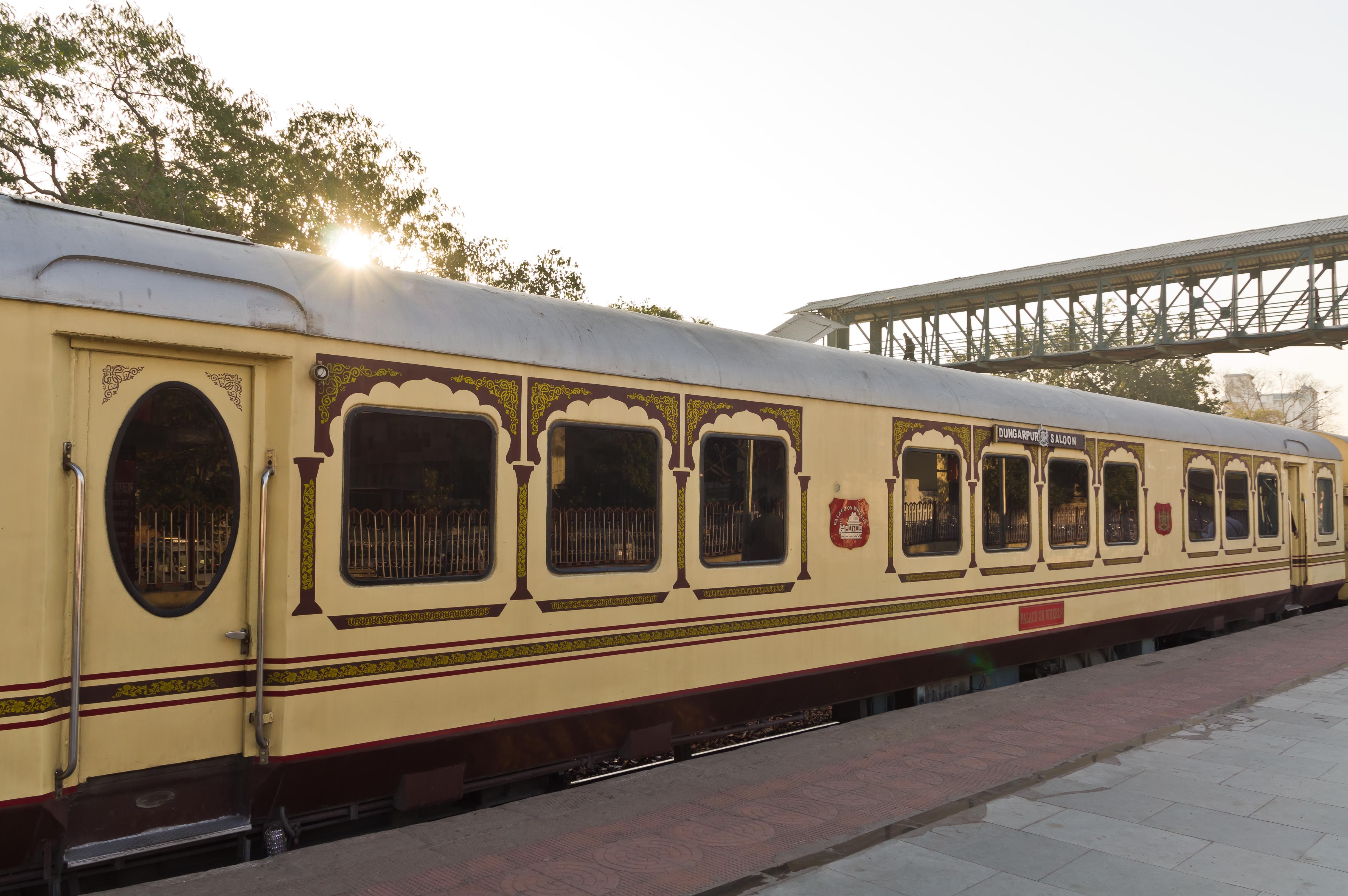 A cream and maroon Palace on Wheels carriage, the Dungarpur Saloon, at a Rajasthan platform