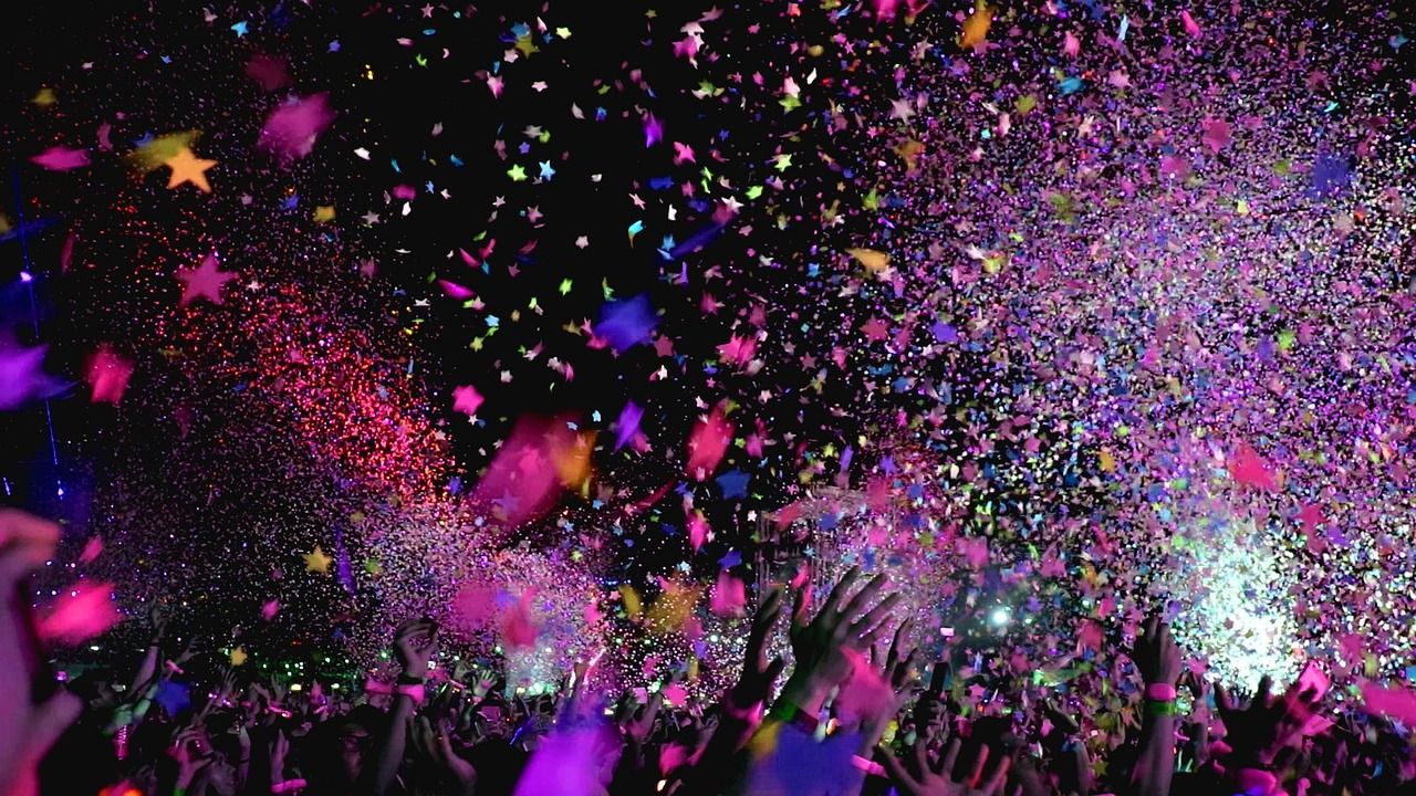 Concert crowd celebrating with confetti falling from above