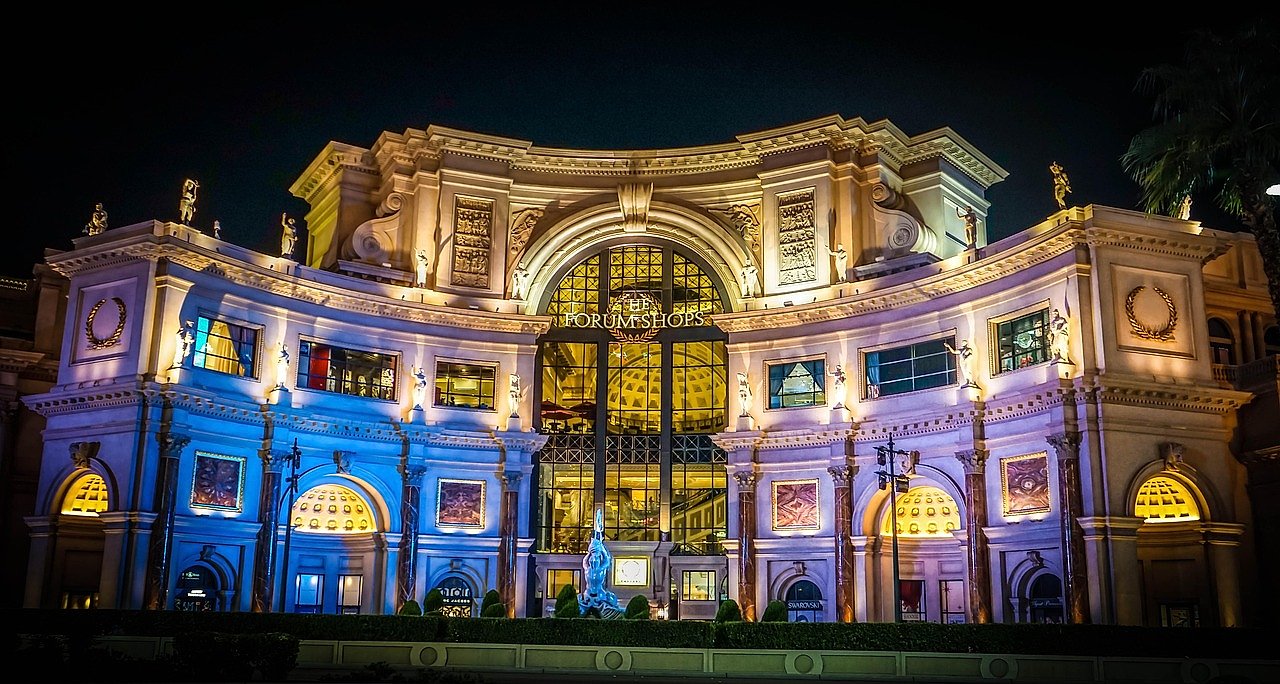 Caesars Palace Las Vegas illuminated at night with reflection in water
