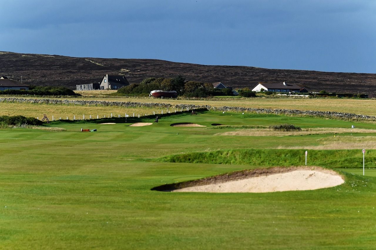 Coastal links golf course with green and flag under open sky