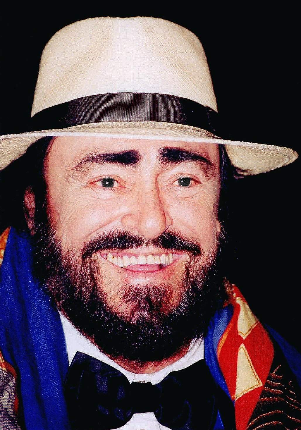 Luciano Pavarotti in a panama hat, smiling