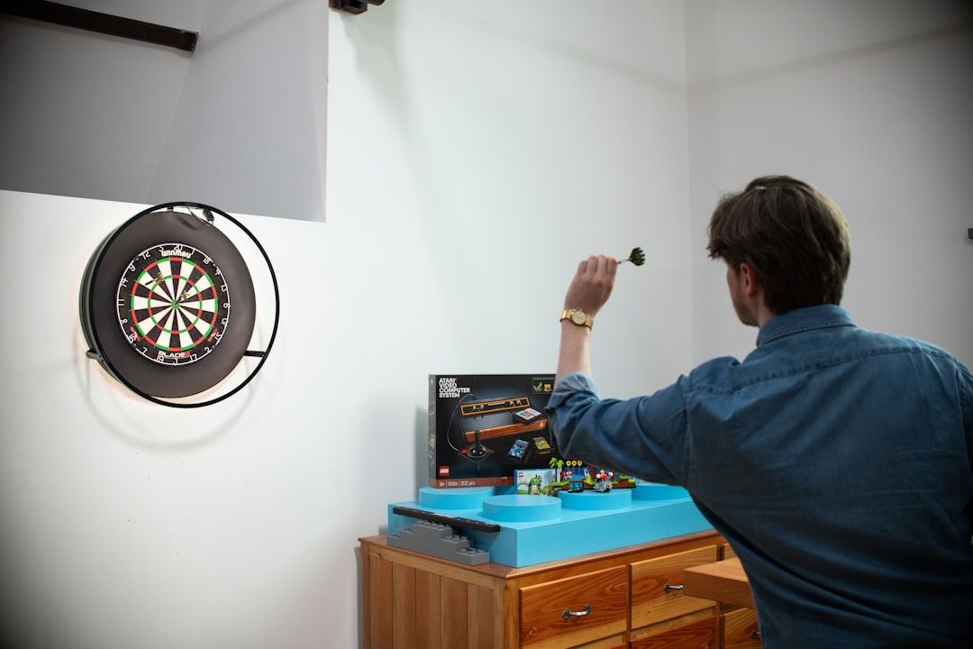 A darts player throwing during a professional match