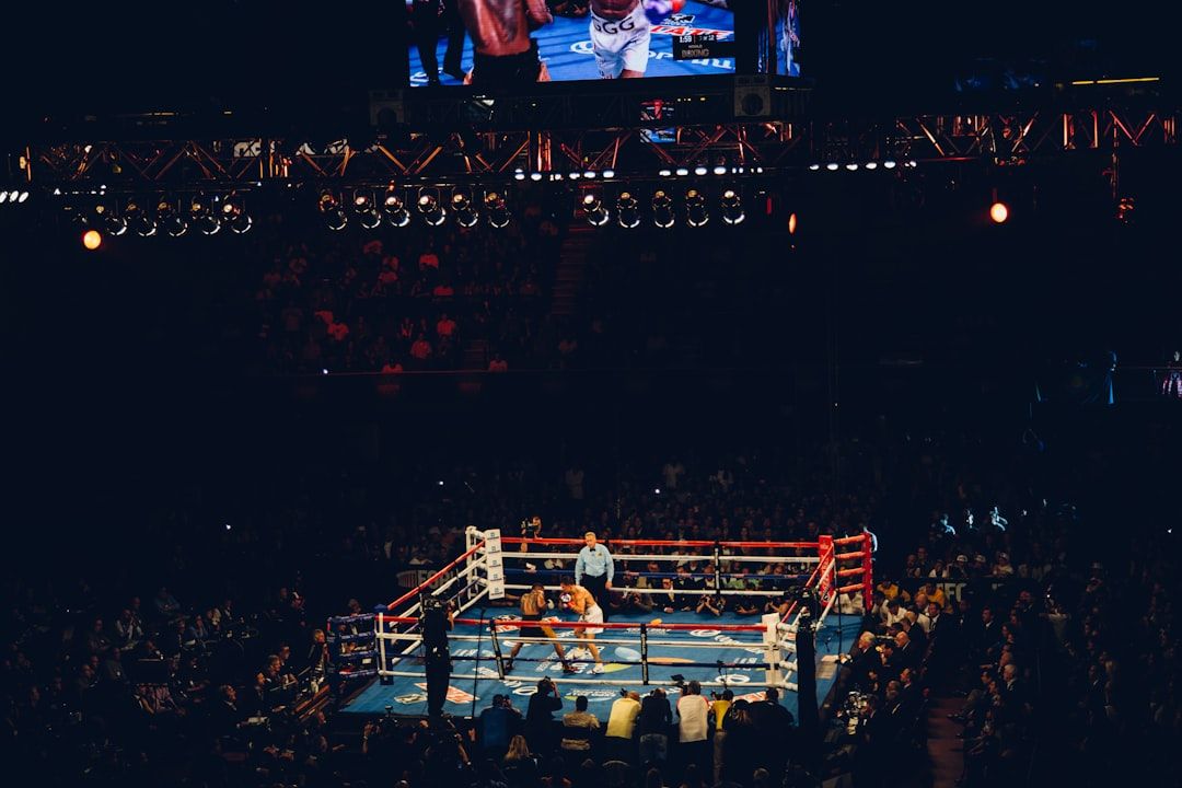 Boxing ring under spotlights in a packed arena