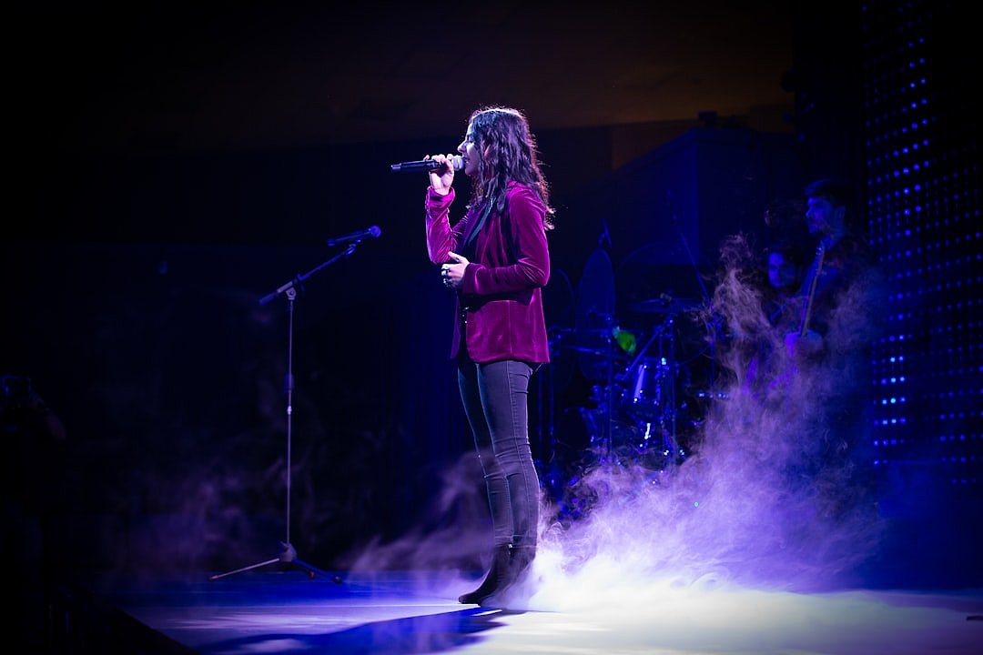 Singer on stage under atmospheric lighting