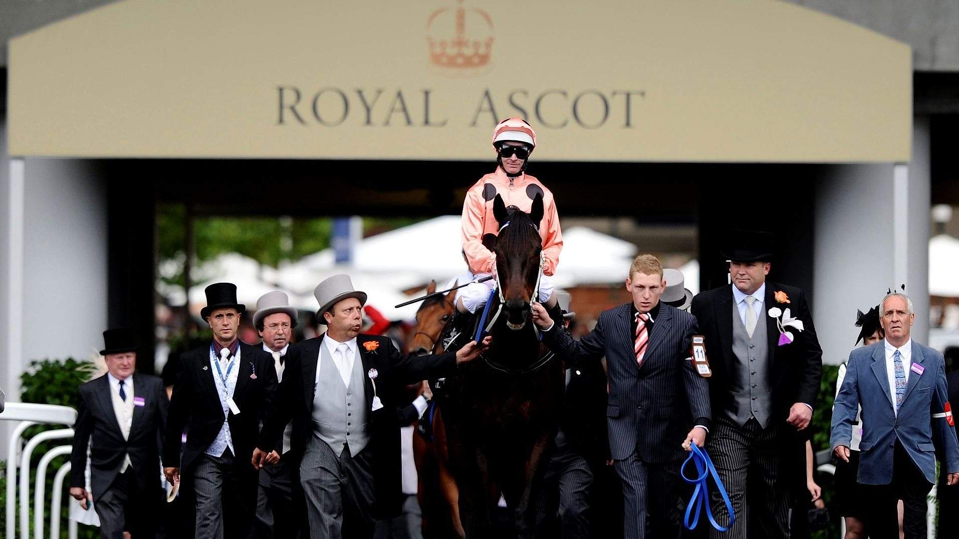 Guests in top hats and morning coats under the ceremonial arch at Royal Ascot